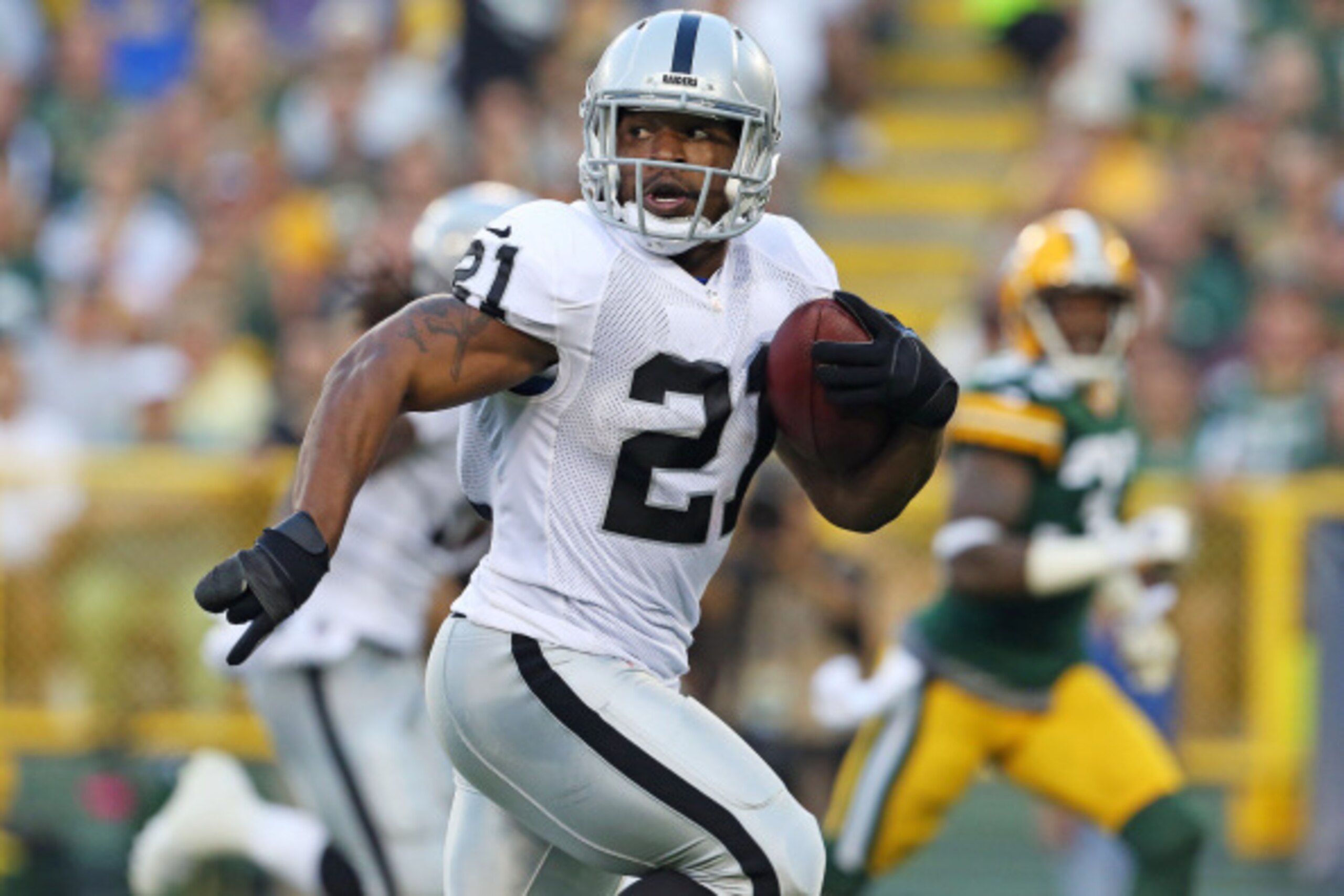GREEN BAY, WI - AUGUST 22:  Maurice Jones Drew #21 of the Oakland Raiders looks back as he runs for a touchdown during the first quarter of a preseason game against the Green Bay Packers at Lambeau Field on August 22, 2014 in Green Bay, Wisconsin. (Photo 