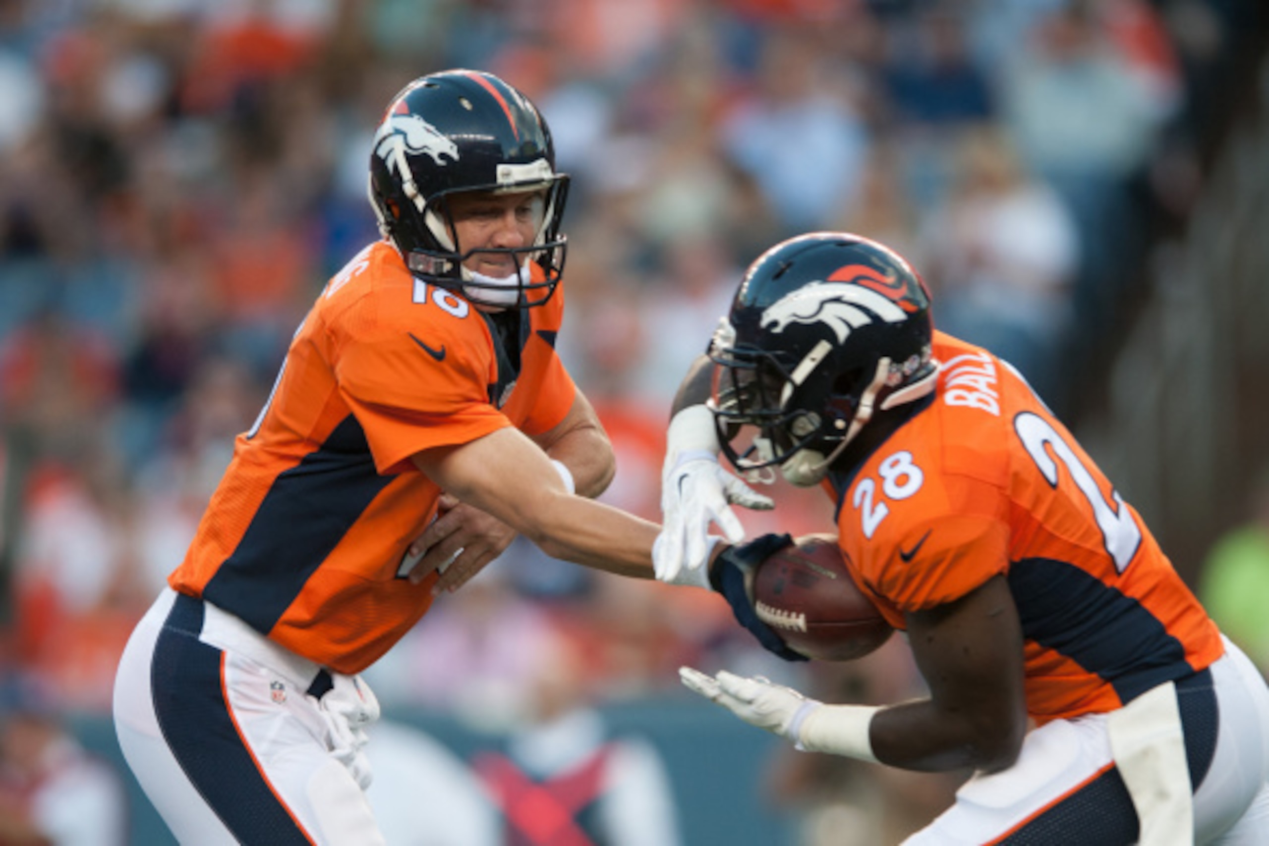 DENVER, CO - AUGUST 23:  Quarterback Peyton Manning #18 of the Denver Broncos hands off to Montee Ball #28 against the Houston Texans during a preseason game at Sports Authority Field at Mile High on August 23, 2014 in Denver, Colorado.  (Photo by Dustin 