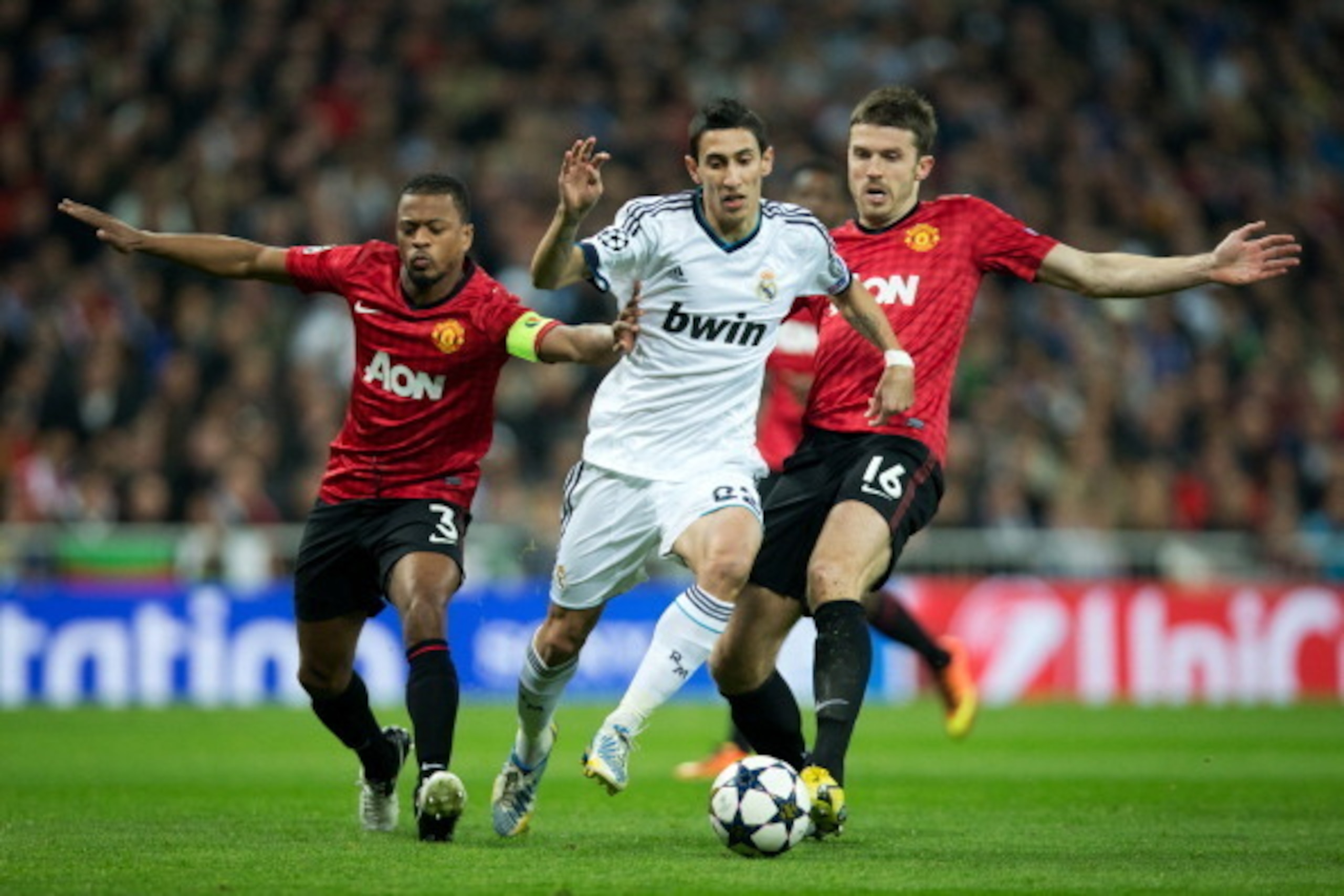 MADRID, SPAIN - FEBRUARY 13:  Angel Di Maria (C) of Real Madrid duels for the ball with Patrice Evra (L) and Michael Carrick of Manchester United during the UEFA Champions League Round of 16 first leg match between Real Madrid and Manchester United at Est