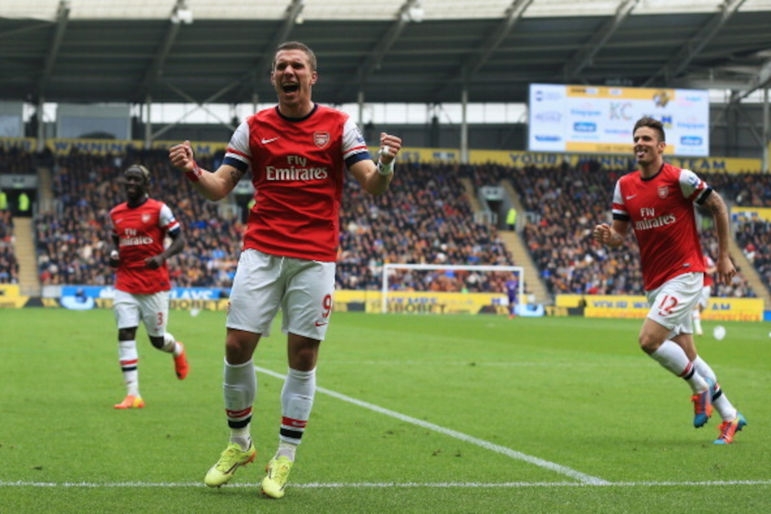 HULL, ENGLAND - APRIL 20:  Lukas Podolski (C) of Arsenal celebrates with team mates Olivier Giroud (R) and Bacary Sagna (L) after scoring his sides third goal during the Barclays Premier League match between Hull City and Arsenal at KC Stadium on April 20