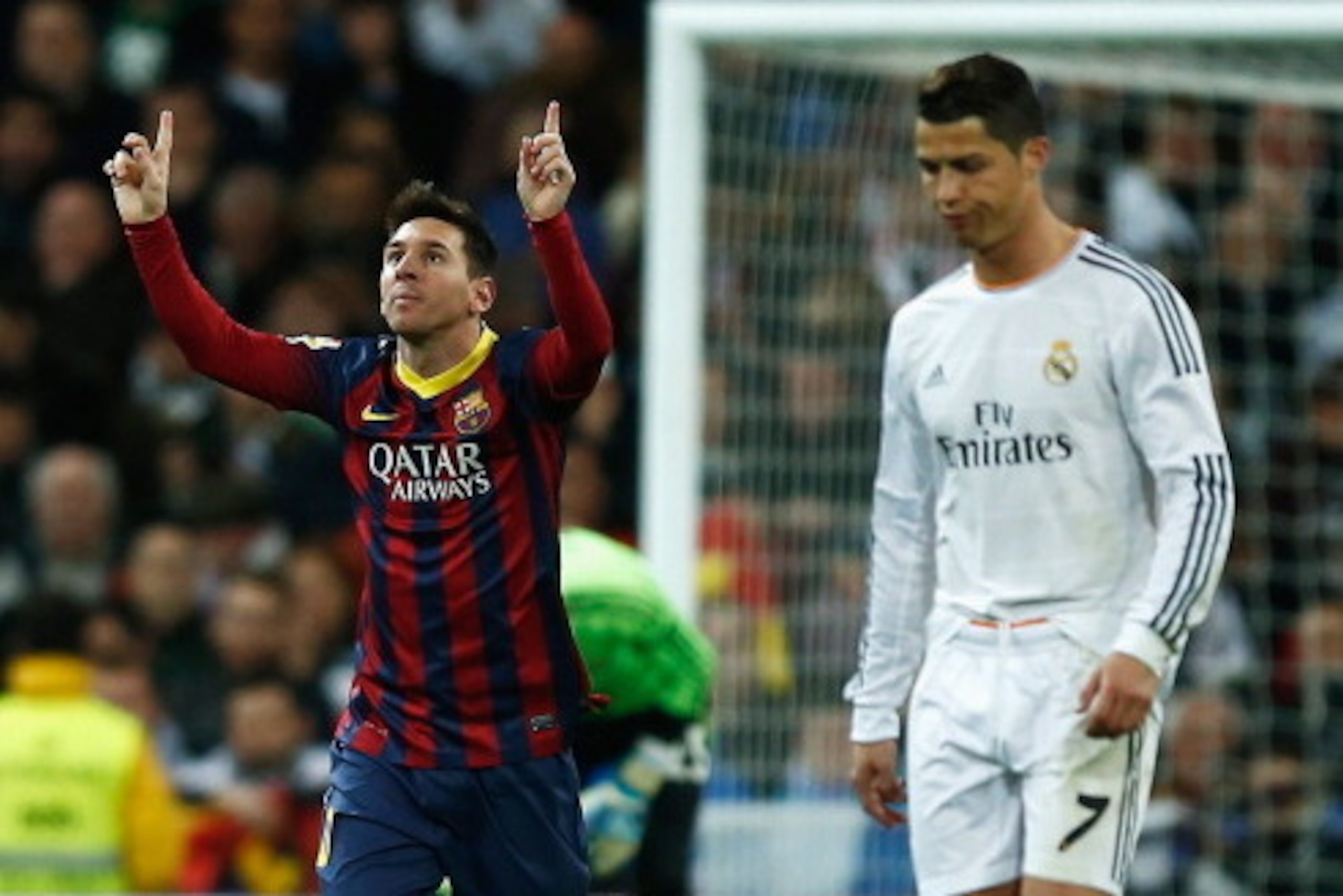 MADRID, SPAIN - MARCH 23:  Lionel Messi of Barcelona celebrates scoring his team's third goal as Cristiano Ronaldo of Real Madrid looks dejected during the La Liga match between Real Madrid CF and FC Barcelona at the Bernabeu on March 23, 2014 in Madrid, 
