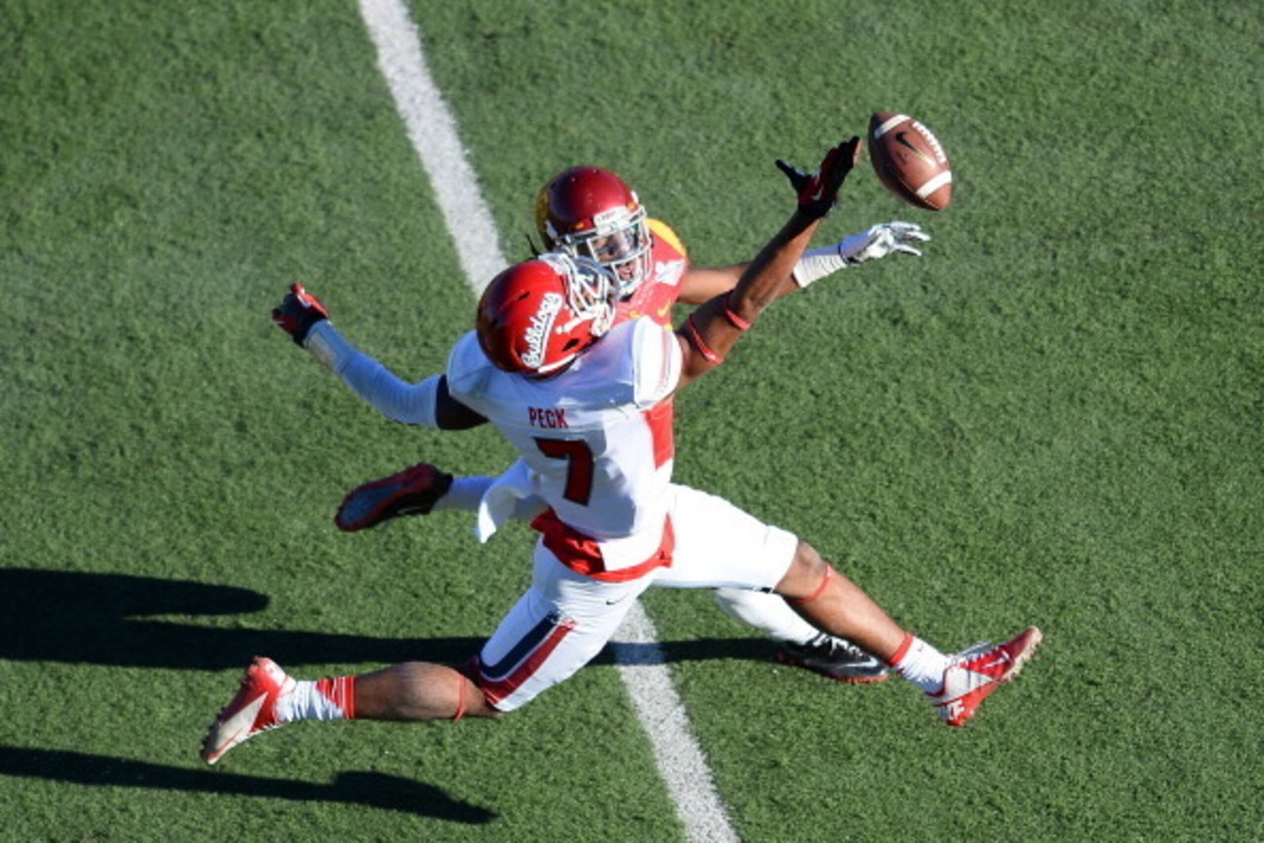 LAS VEGAS, NV - DECEMBER 21:  Aaron Peck #7 of the Fresno State Bulldogs misses a pass as Kevon Seymour #13 of the USC Trojans defends during the Royal Purple Las Vegas Bowl at Sam Boyd Stadium on December 21, 2013 in Las Vegas, Nevada.  (Photo by Ethan M