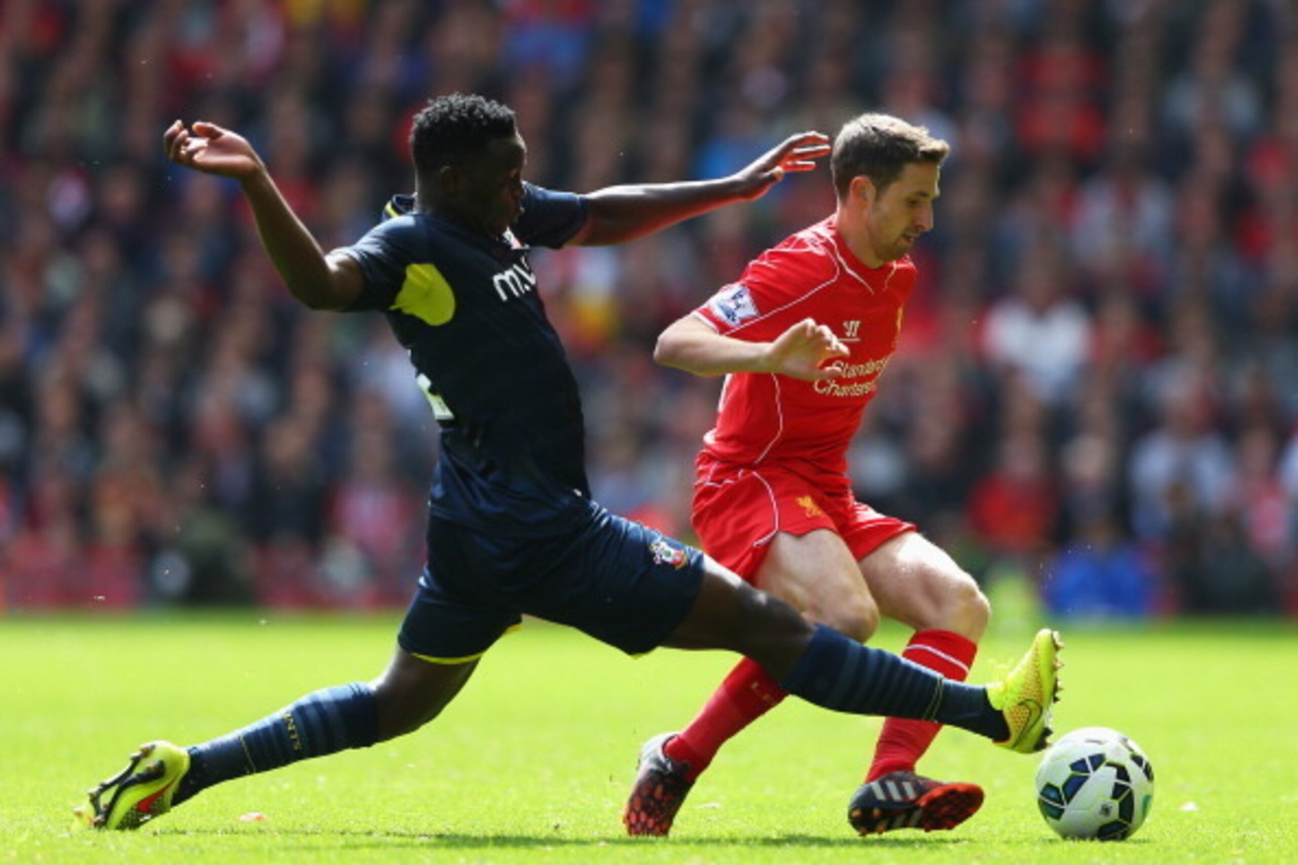 LIVERPOOL, ENGLAND - AUGUST 17: Joe Allen of Liverpool is tackled by Victor Wanyama of Southampton during the Barclays Premier League match between Liverpool and Southampton at Anfield on August 17, 2014 in Liverpool, England.  (Photo by Alex Livesey/Gett