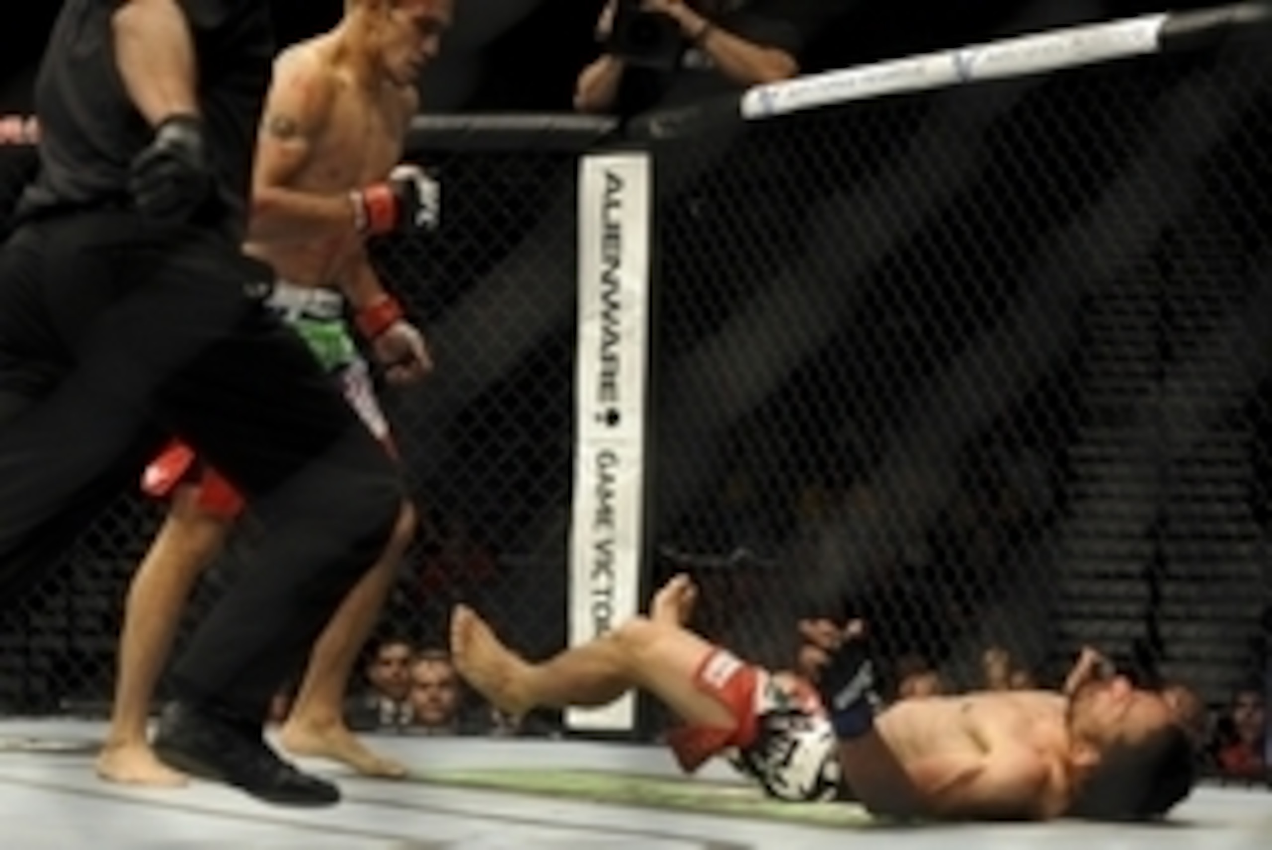May 24, 2014; Las Vegas, NV, USA; Tony Ferguson (red) watches Katsunori Kikuno (blue) fall to the mat after landing a TKO punch during their UFC 173 welterweight bout at MGM Grand Garden Arena. Ferguson won the bout by TKO. Mandatory Credit: Stephen R. Sy