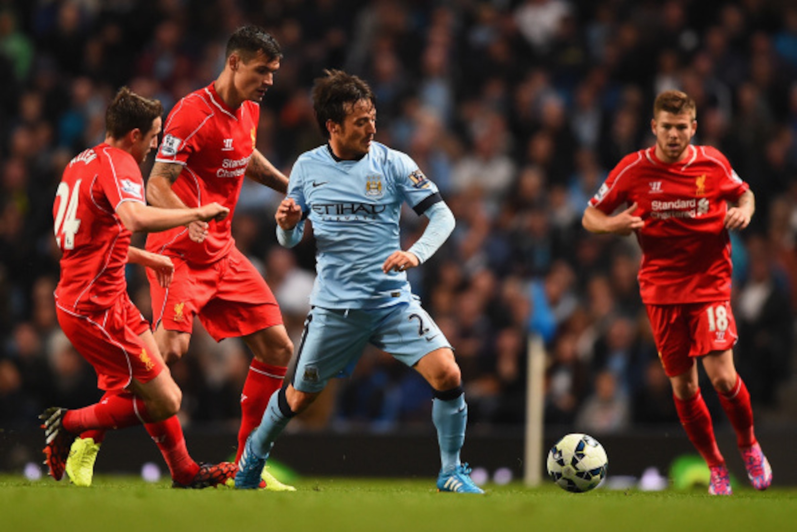 MANCHESTER, ENGLAND - AUGUST 25:  David Silva of Manchester City competes with Dejan Lovren and Joe Allen of Liverpool during the Barclays Premier League match between Manchester City and Liverpool at the Etihad Stadium on August 25, 2014 in Manchester, E