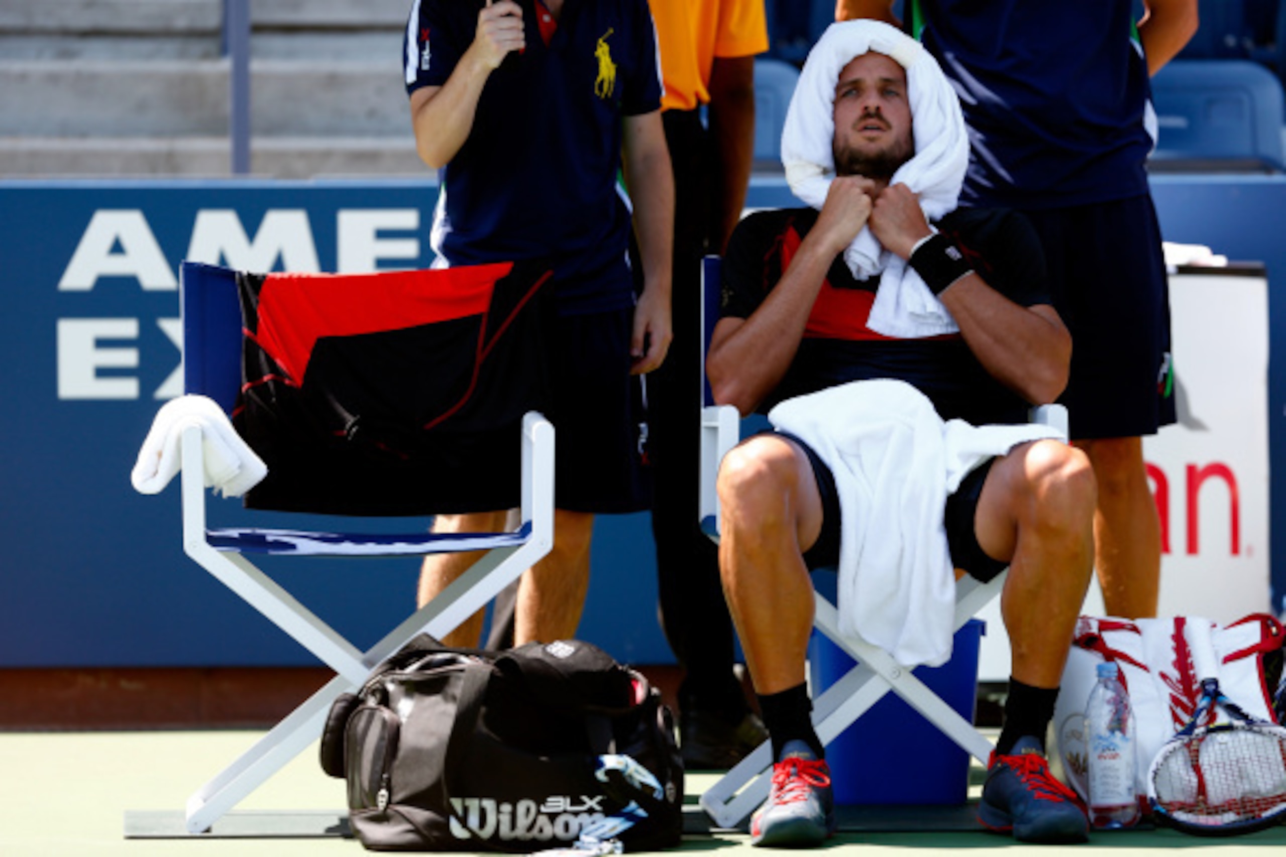 NEW YORK, NY - AUGUST 27:  Feliciano Lopez of Spain sits down during a break in play against Ivan Dodig of Croatia during their men's singles first round match on Day Three of the 2014 US Open at the USTA Billie Jean King National Tennis Center on August 