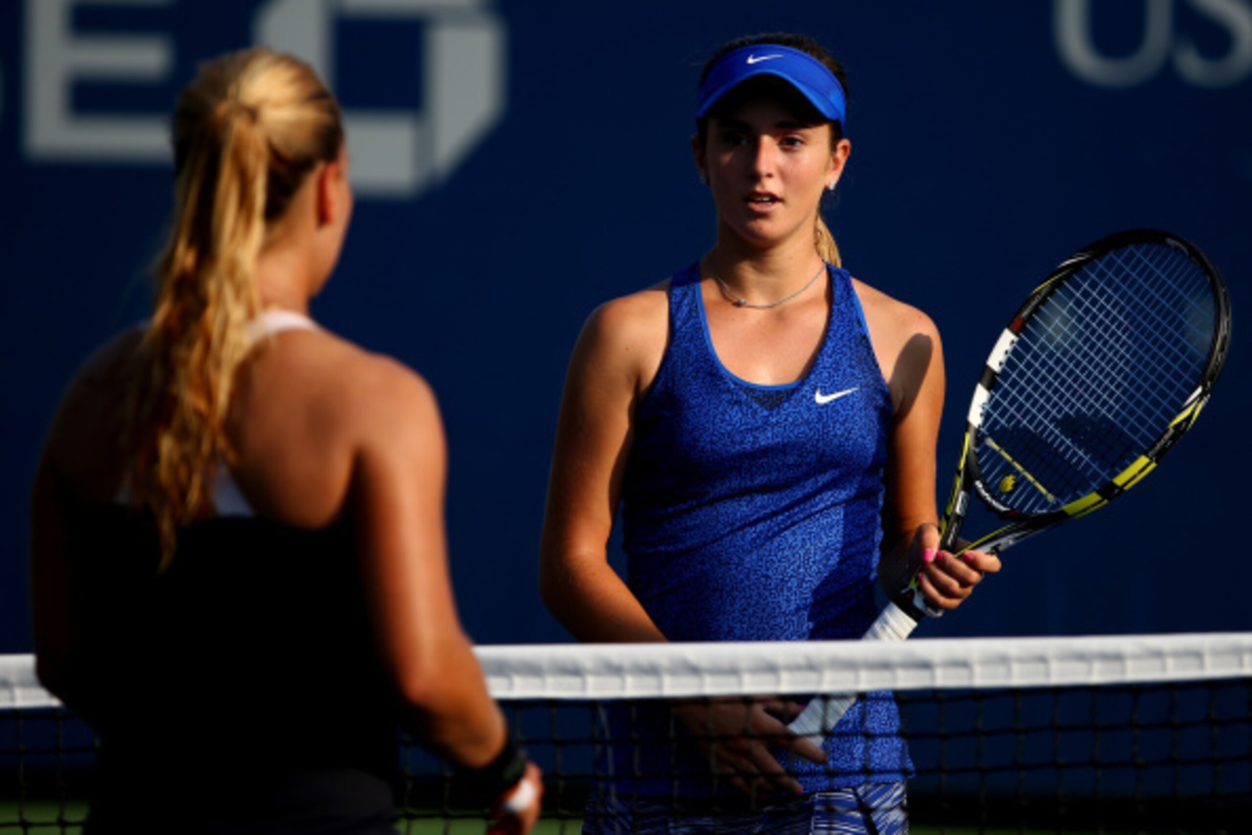 NEW YORK, NY - AUGUST 26:  Catherine Bellis (R) of the United States walks to the net after defeating Dominika Cibulkova of Slovakia during their women's singles first round match on Day Two of the 2014 US Open at the USTA Billie Jean King National Tennis
