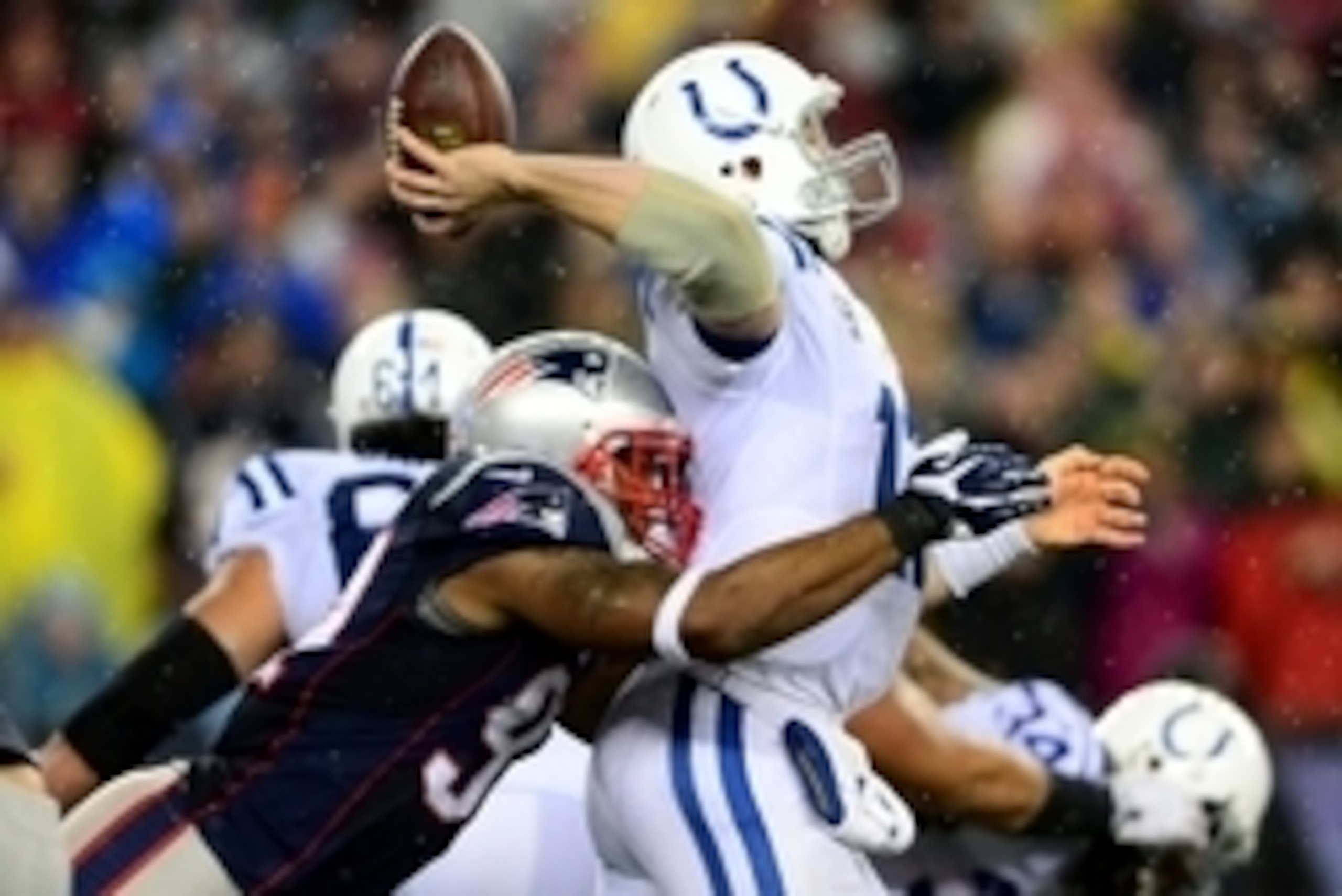 Jan 11, 2014; Foxborough, MA, USA; Indianapolis Colts quarterback Andrew Luck (12) throws a pass while being hit by New England Patriots outside linebacker Jamie Collins (91)  during the third quarter of the 2013 AFC divisional playoff football game at Gi