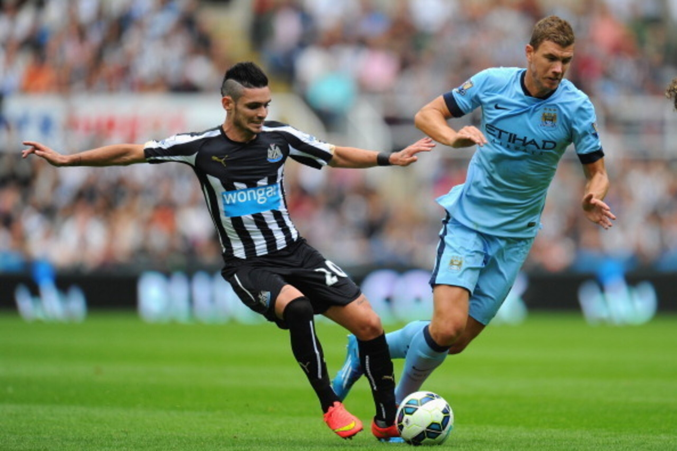NEWCASTLE UPON TYNE, ENGLAND - AUGUST 17: Newcastle player Remy Cabella (l) challenges Edin Dzeko of Man City during the Barclays Premier League match between Newcastle United and Manchester City at St James' Park on August 17, 2014 in Newcastle upon Tyn NEWCASTLE UPON TYNE, ENGLAND - AUGUST 17: Newcastle player Remy Cabella (l) challenges Edin Dzeko of Man City during the Barclays Premier League match between Newcastle United and Manchester City at St James' Park on August 17, 2014 in Newcastle upon Tyn