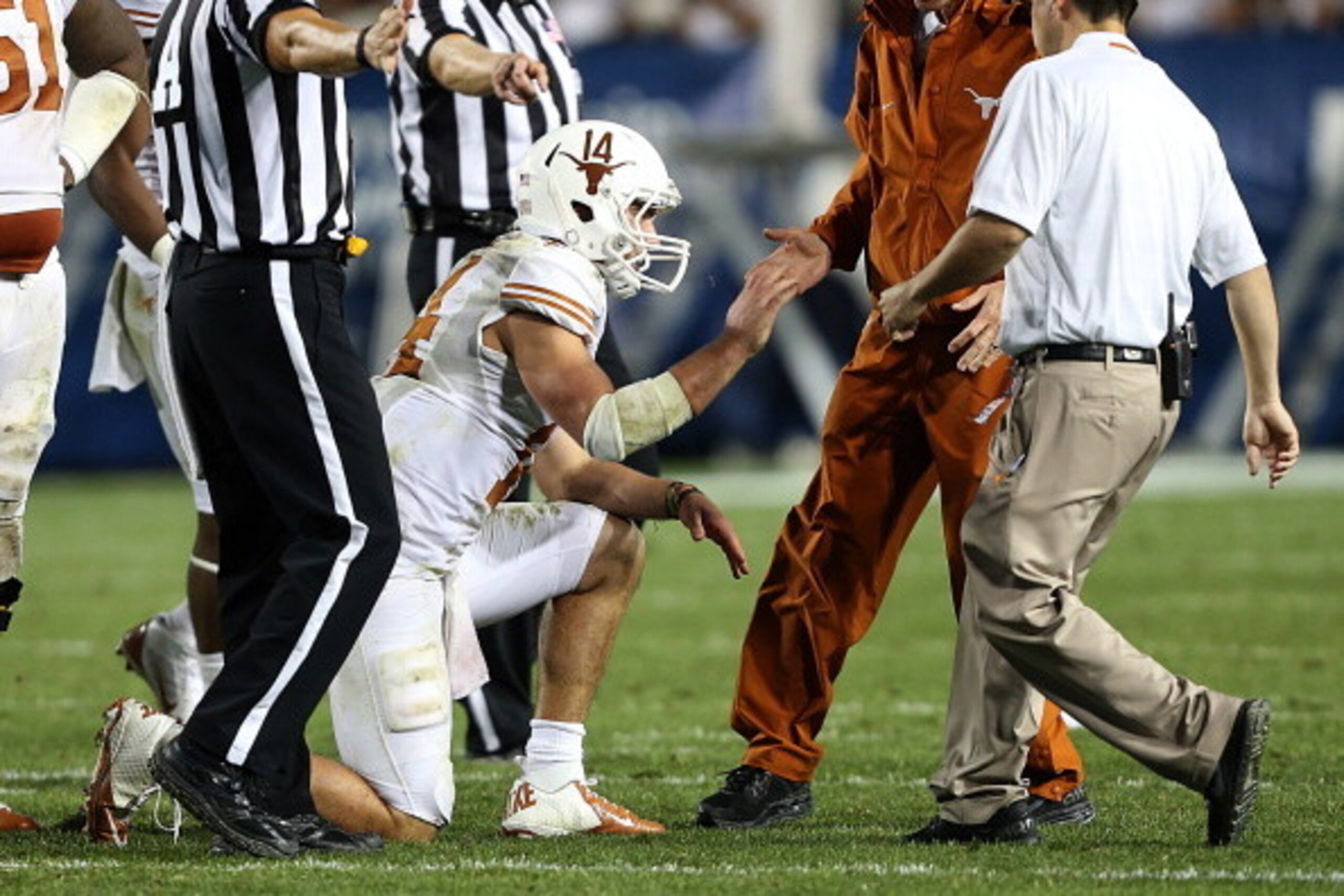 PROVO, UT - SEPTEMBER 7: Quarterback David Ash #14 of the Texas Longhorns is assisted by trainers after he was hurt on a play against the BYU Cougars during the second half of an NCAA football game September 7, 2013 at LaVell Edwards Stadium in Provo, Uta