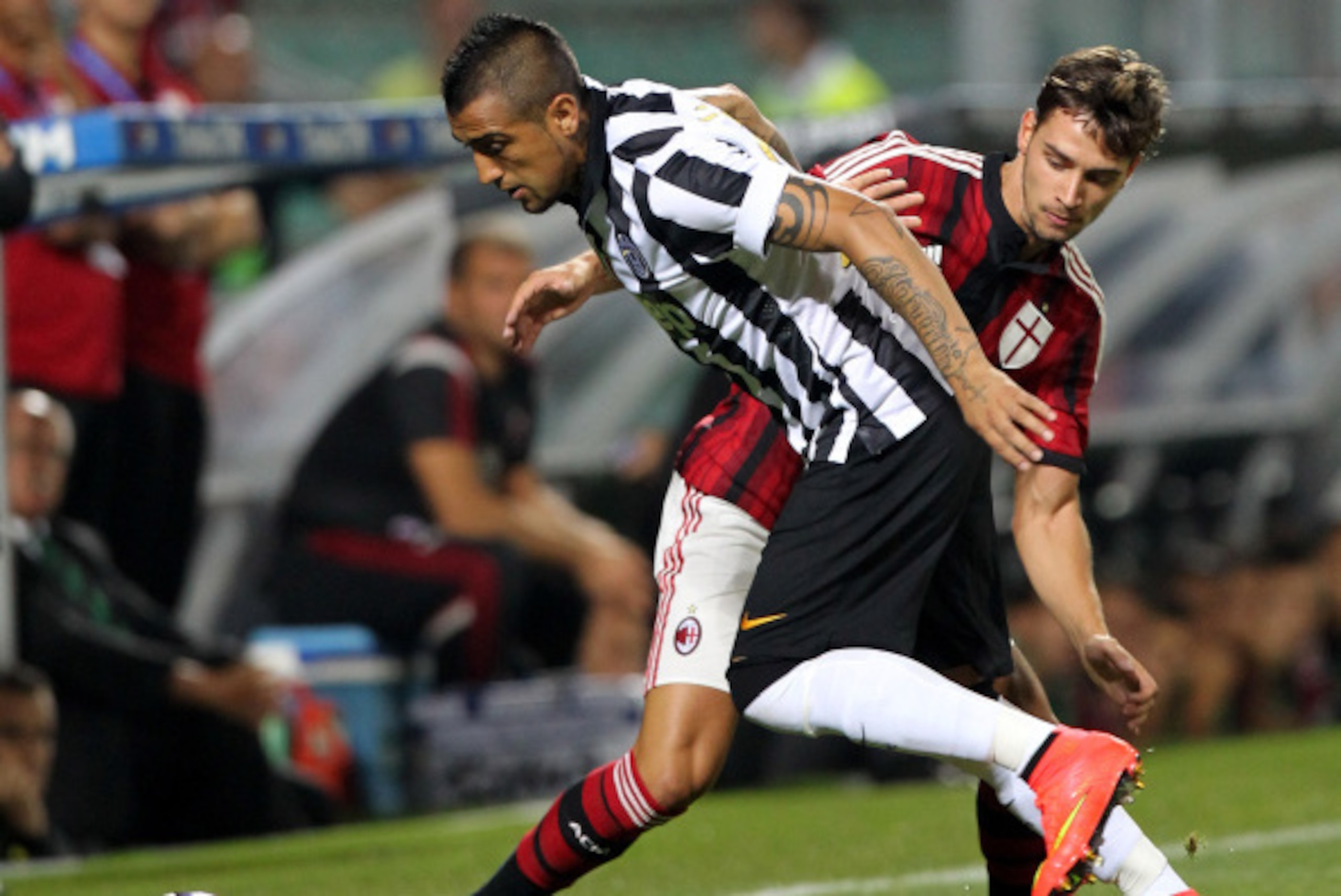 REGGIO NELL'EMILIA, ITALY - AUGUST 23:  Arturo Vidal (L) of FC Juventus competes for the ball with Mattia De Sciglio of AC Milan during the TIM Preseason Tournament between US Sassuolo, FC Juventus and AC Milan at Mapei Stadium - Citta' del Tricolore on A