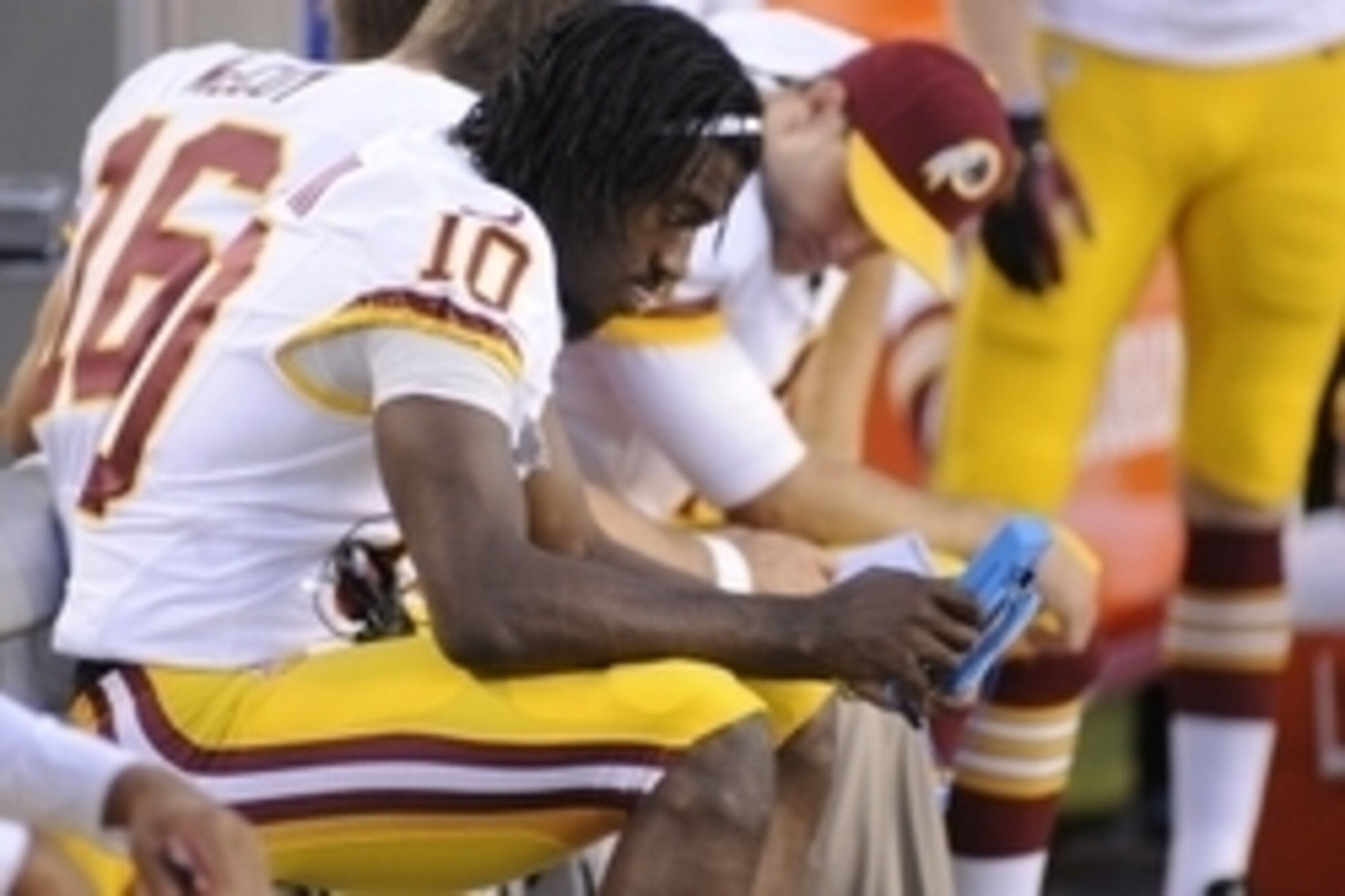 Aug 28, 2014; Tampa, FL, USA; Washington Redskins quarterback Robert Griffin III (10) looks at photos on the bench in the first quarter as the Washington Redskins play the Tampa Bay Buccaneers at Raymond James Stadium. Mandatory Credit: David Manning-USA