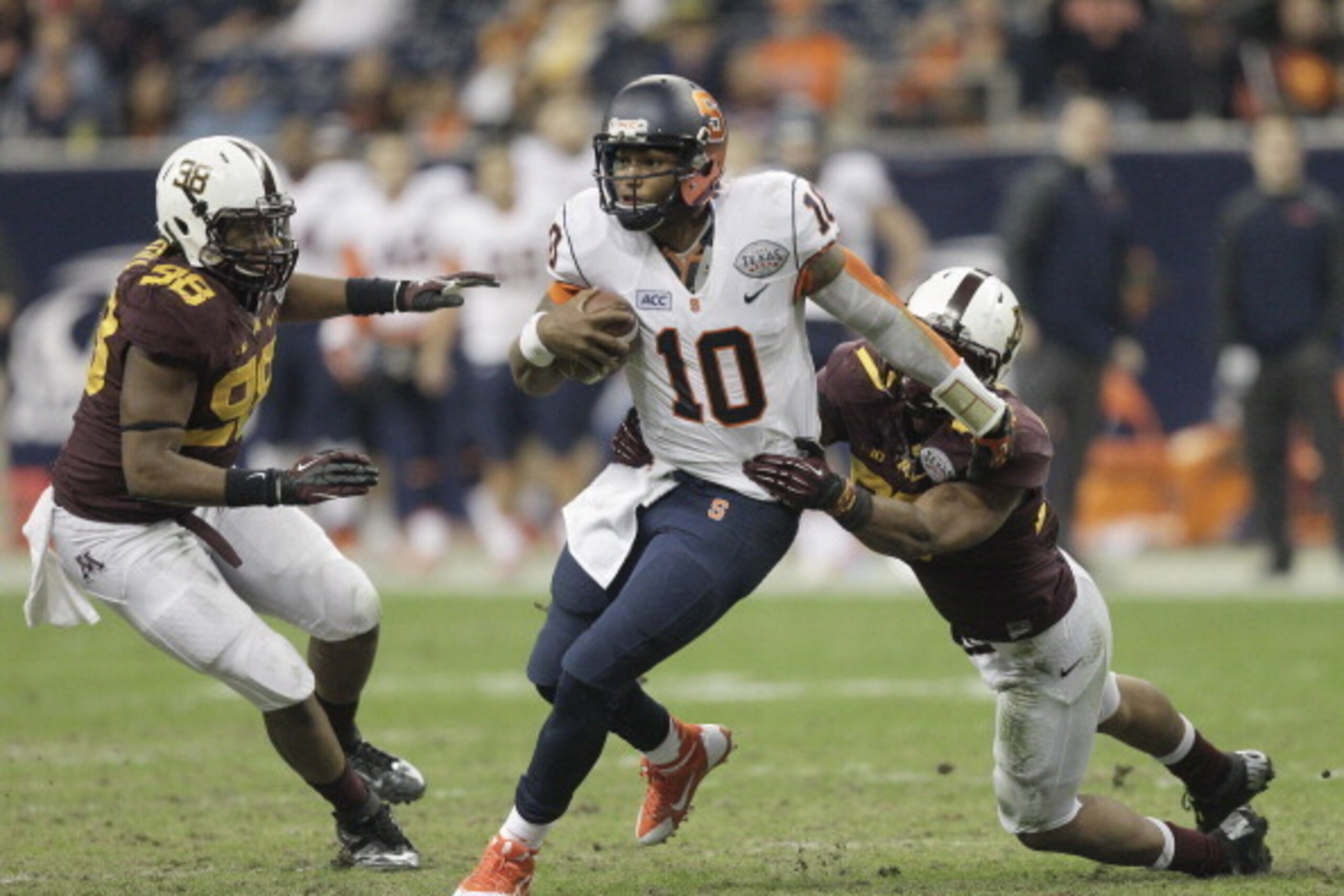 HOUSTON, TX - DECEMBER 27:  Terrel Hunt #10 of the Syracuse Orange shakes off a tackle attempt by Ra'Shede Hageman #99 of the Minnesota Golden Gophers and Michael Amaefula #98 in the fourth quarter at Reliant Stadium on December 27, 2013 in Houston, Texas