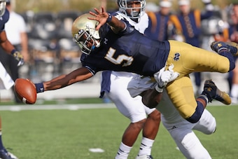 SOUTH BEND, IN - AUGUST 30: Everett Golson #5 of the Norte Dame Fighting Irish dives into the end zone for a touchdown dragging Julius White #7 of the Rice Owls at Notre Dame Stadium on August 30, 2014 in South Bend, Indiana. (Photo by Jonathan Daniel/Get