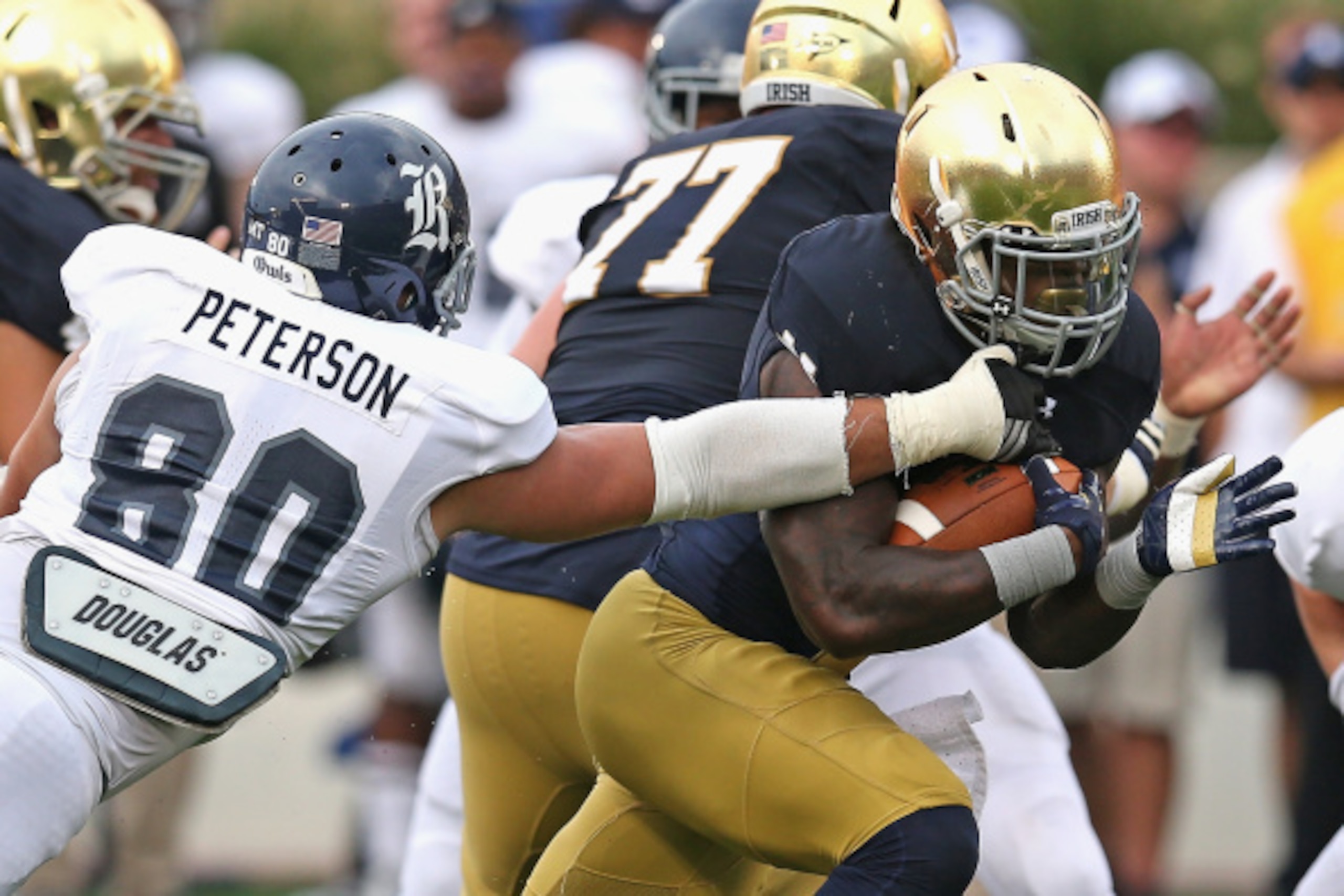 SOUTH BEND, IN - AUGUST 30:  Greg Bryant #1 of the Notre Dame Fighting Irish breaks a tackle attempt by Grant Peterson #80 of the Rice Owls on a 17 yard touchdown run at Notre Dame Stadium on August 30, 2014 in South Bend, Indiana. Notre Dame defeated Ric