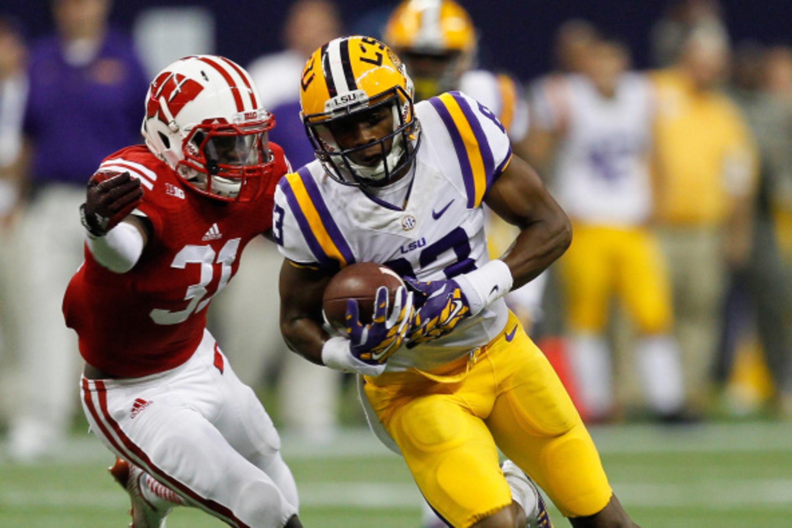 HOUSTON, TX - AUGUST 30:  Travin Dural #83 of the LSU Tigers runs with the ball after a reception as Lubern Figaro #31 of the Wisconsin Badgers attempts a tackle at NRG Stadium on August 30, 2014 in Houston, Texas.  (Photo by Bob Levey/Getty Images)
