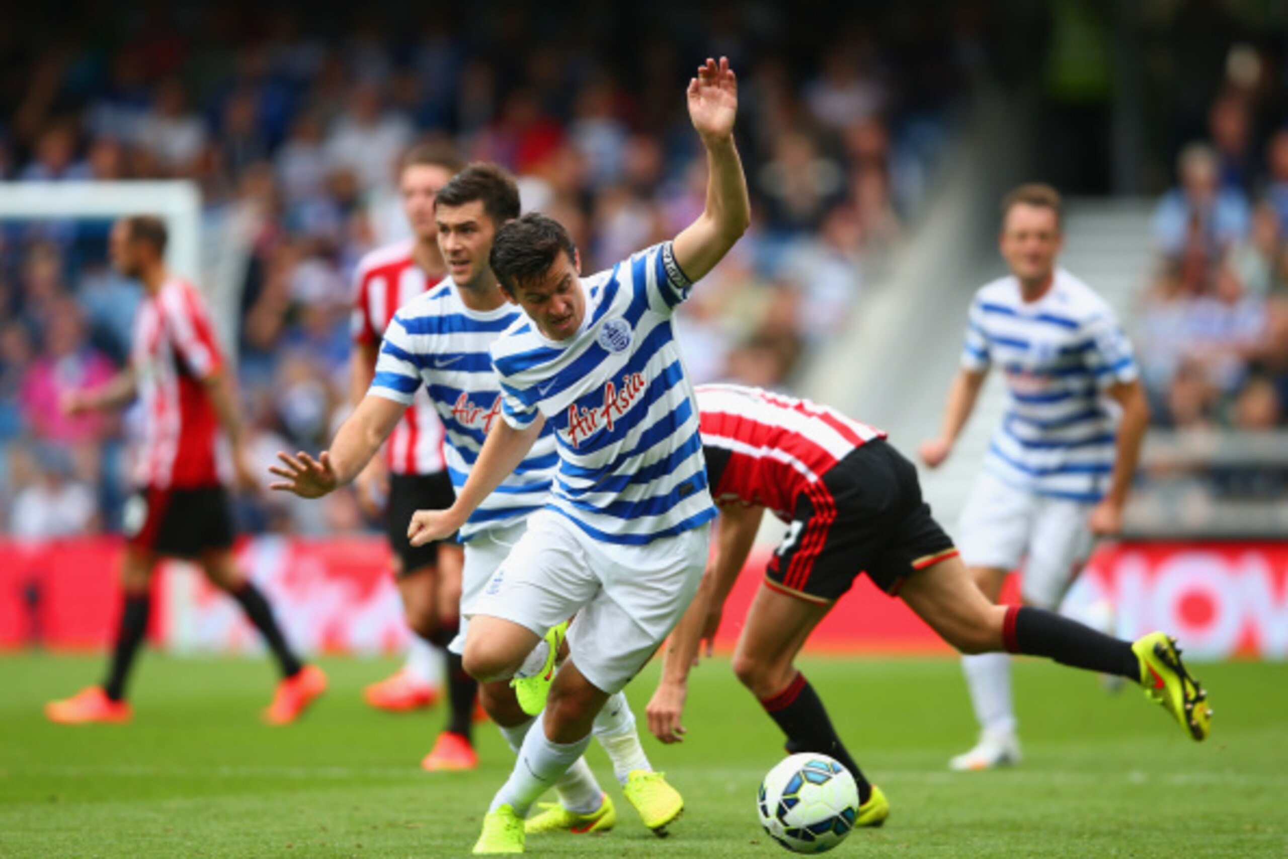 LONDON, ENGLAND - AUGUST 30:  Joey Barton of QPR and Sebastian Larsson of Sunderland compete for the bsll during the Barclays Premier League match between Queens Park Rangers and Sunderland at Loftus Road on August 30, 2014 in London, England.  (Photo by 