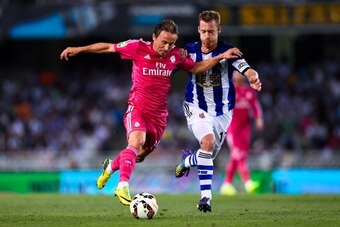 SAN SEBASTIAN, SPAIN - AUGUST 31:  Luka Modric of Real Madrid CF competes for the ball with David Zurutuza Veillet of Real Sociedad during the La Liga match between Real Sociedad de Futbol and Real Madrid CF at Estadio Anoeta on August 31, 2014 in San Seb