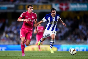 SAN SEBASTIAN, SPAIN - AUGUST 31:  Gareth Bale of Real Madrid CF competes for the ball with Joseba Zaldua of Real Sociedad during the La Liga match between Real Sociedad de Futbol and Real Madrid CF at Estadio Anoeta on August 31, 2014 in San Sebastian, S