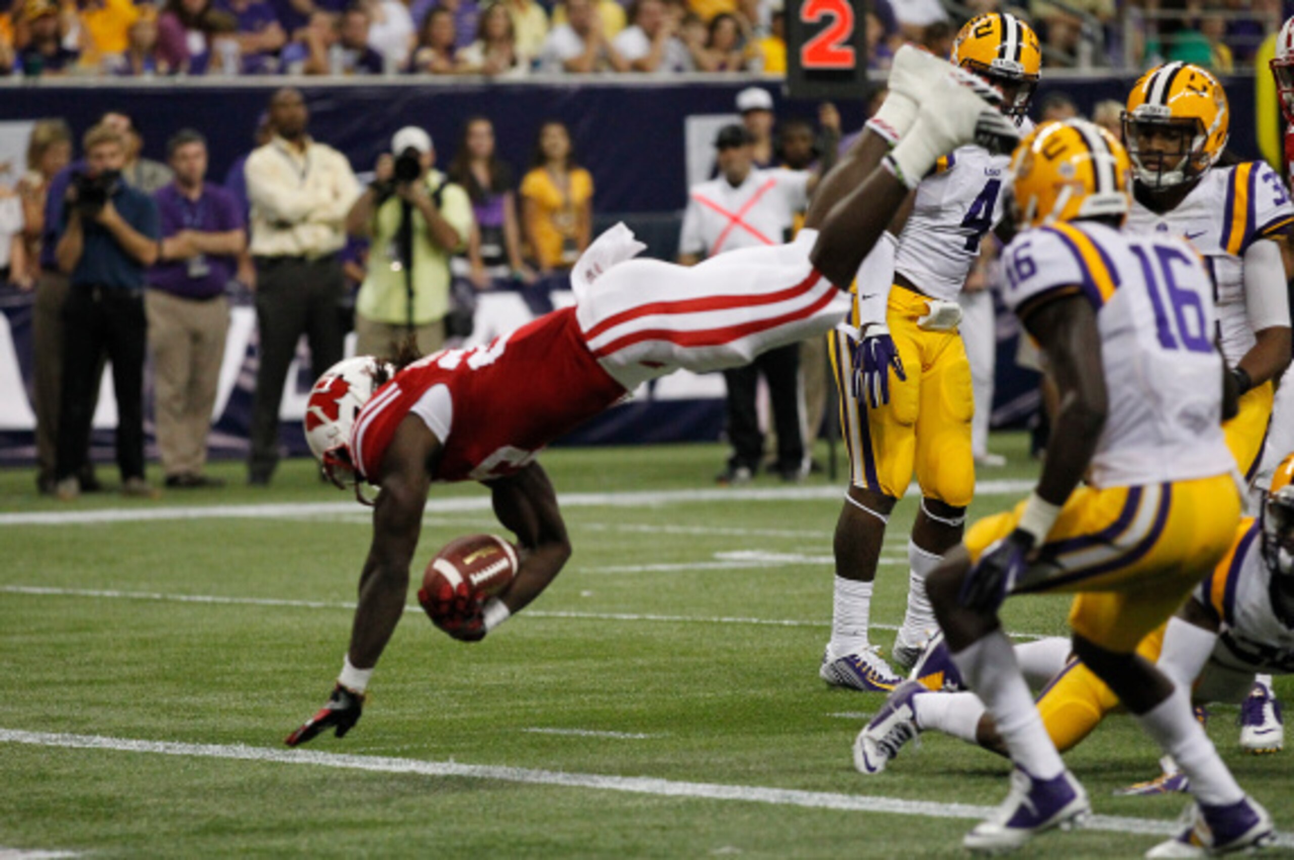 HOUSTON, TX - AUGUST 30:  Melvin Gordon #25 of the Wisconsin Badgers dives over Jalen Mills #18 of the LSU Tigers for a touchdown in the second quarter at NRG Stadium on August 30, 2014 in Houston, Texas.  (Photo by Bob Levey/Getty Images)