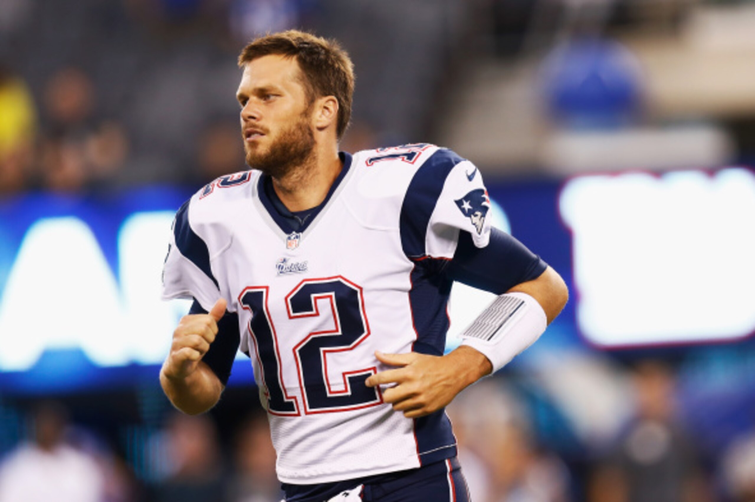 EAST RUTHERFORD, NJ - AUGUST 28:  Tom Brady #12 of the New England Patriots runs onto the field before the preseason game against the New York Giants at MetLife Stadium on August 28, 2014 in East Rutherford, New Jersey.  (Photo by Jeff Zelevansky/Getty Im