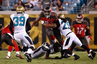 JACKSONVILLE, FL - AUGUST 08: Austin Seferian-Jenkins #87 of the Tampa Bay Buccaneers is tackled by Jamell Fleming #29 of the Jacksonville Jaguars during the second half of the preseason game at Everbank Field on August 8, 2014 in Jacksonville, Florida.  