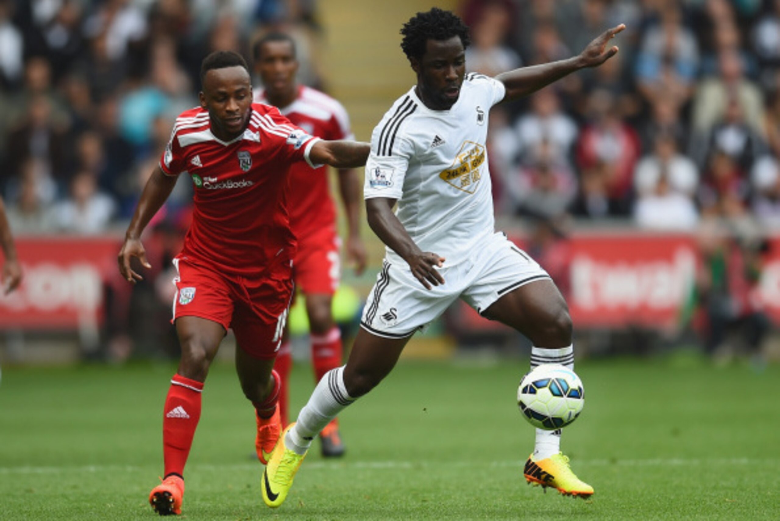 SWANSEA, WALES - AUGUST 30:  Wilfried Bony of Swansea gets away from Saido Berahino of West Brom during the Barclays Premier League match between Swansea City and West Bromwich Albion at Liberty Stadium on August 30, 2014 in Swansea, Wales.  (Photo by Chr