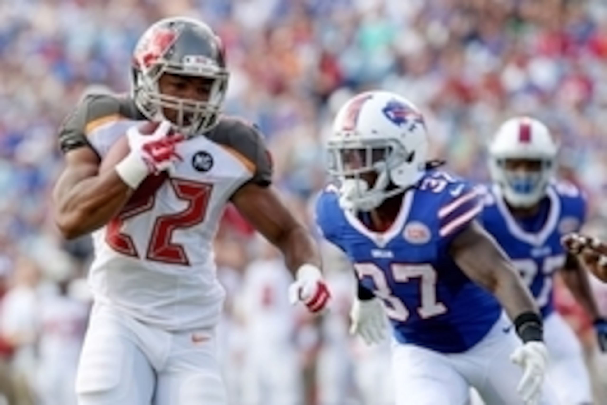 Aug 23, 2014; Orchard Park, NY, USA; Tampa Bay Buccaneers running back Doug Martin (22) runs the ball while being defended by Buffalo Bills defensive back Nickell Robey (37) during the first half at Ralph Wilson Stadium. Mandatory Credit: Timothy T. Ludwi