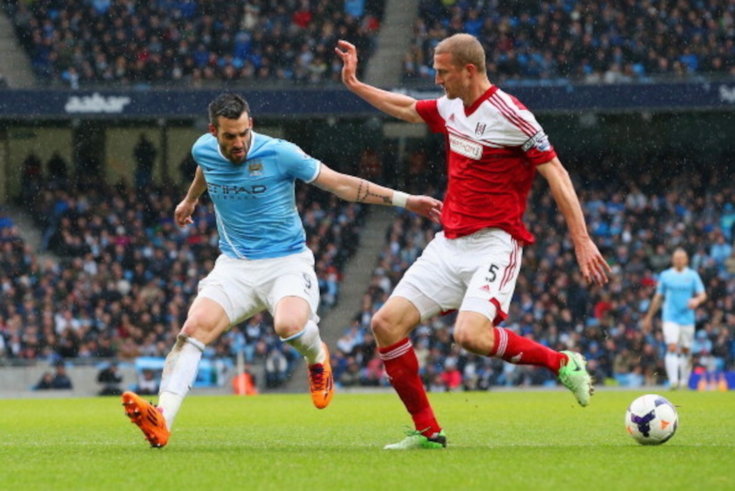 MANCHESTER, ENGLAND - MARCH 22: Alvaro Negredo of Manchester City and Brede Hangeland of Fulham compete for the ball during the Barclays Premier League match between Manchester City and Fulham at Etihad Stadium on March 22, 2014 in Manchester, England.  (