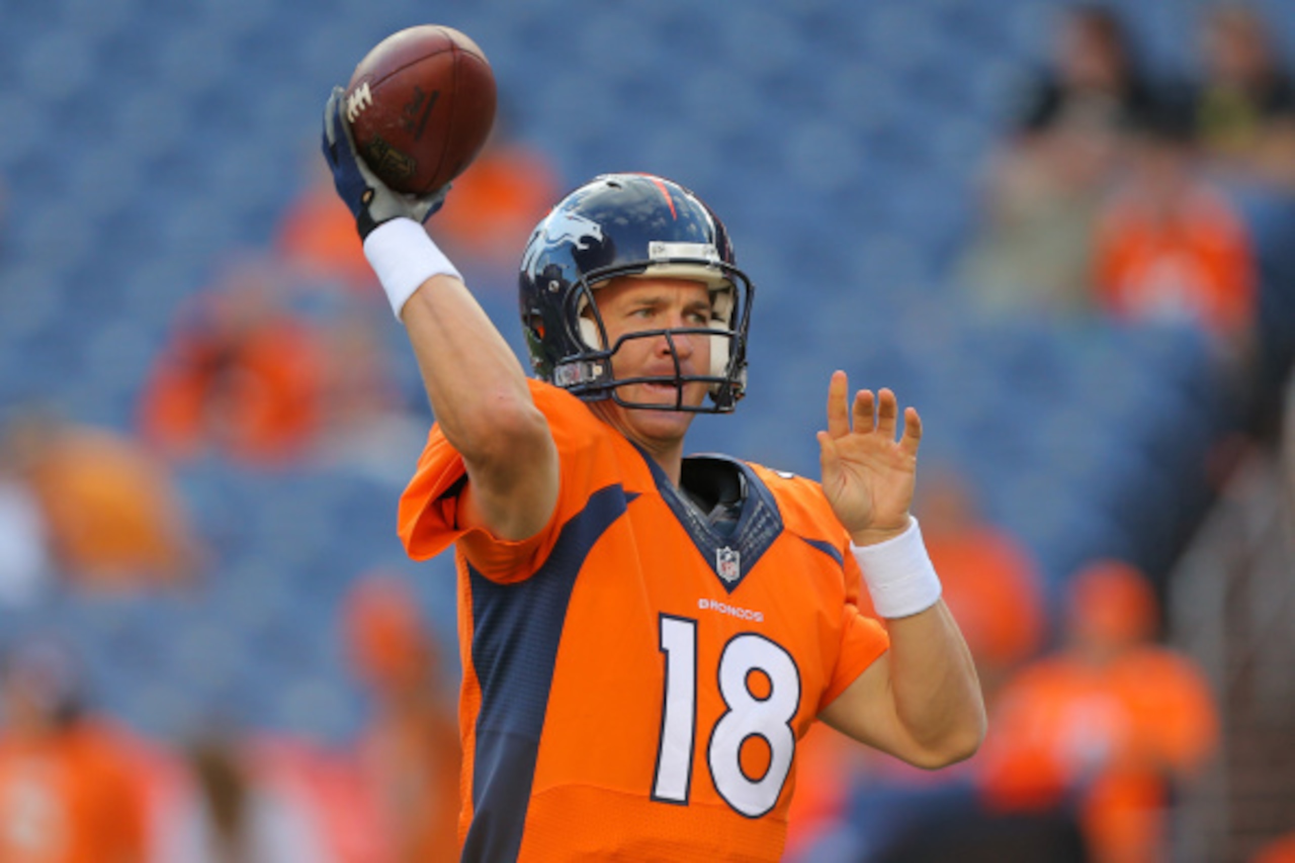 DENVER, CO - AUGUST 23:  Quarterback Peyton Manning #18 of the Denver Broncos throws as he warms up before a preseason game at Sports Authority Field at Mile High on August 23, 2014 in Denver, Colorado.  (Photo by Justin Edmonds/Getty Images)