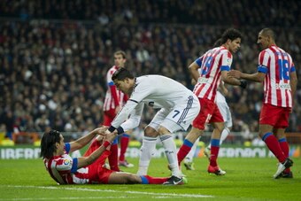 MADRID, SPAIN - DECEMBER 01: Cristiano Ronaldo (R) of Real Madrid helps up Falcao of Club Atletico de Madrid during the la Liga match between Real Madrid CF and Club Atletico de Madrid at Estadio Santiago Bernabeu on December 1, 2012 in Madrid, Spain.  (P