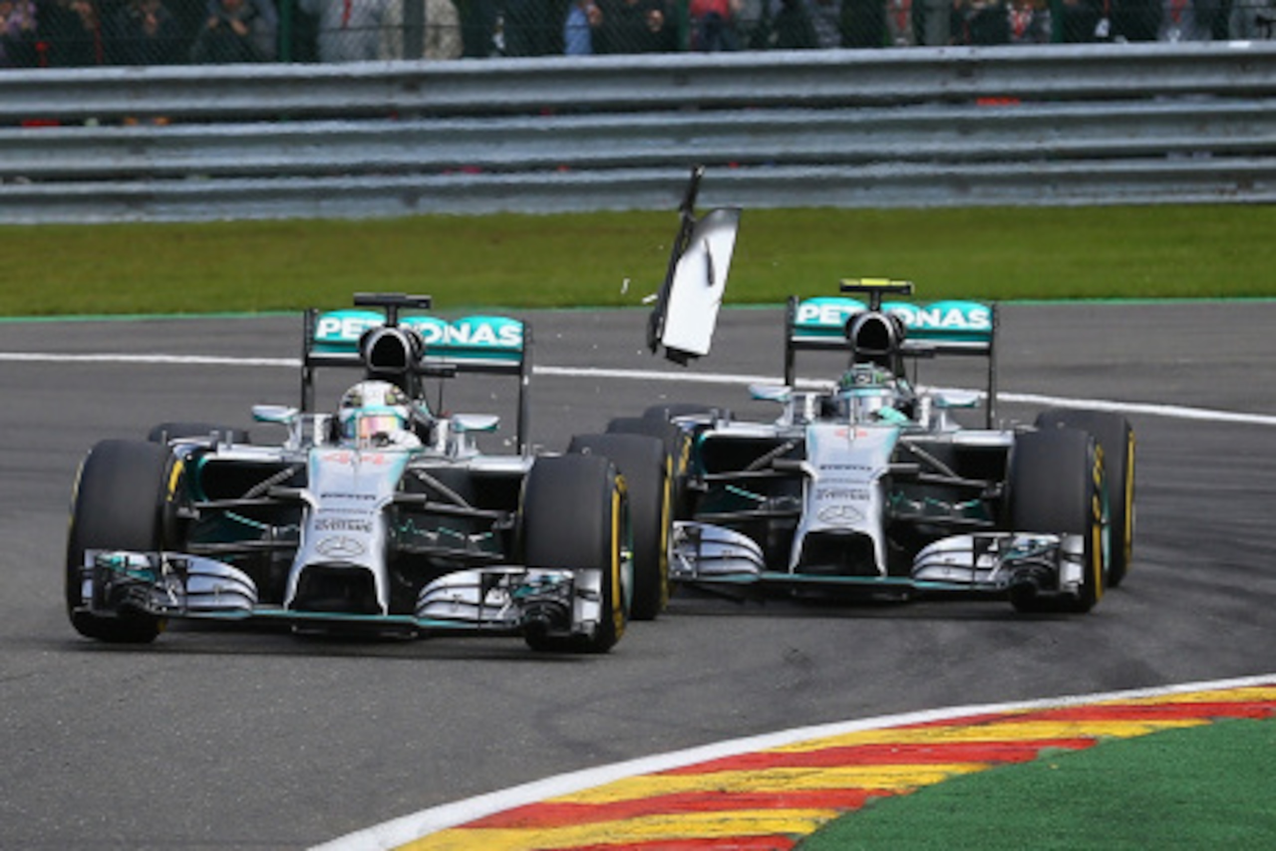 SPA, BELGIUM - AUGUST 24:  Debris flies in the air as Nico Rosberg of Germany and Mercedes GP makes contact with Lewis Hamilton of Great Britain and Mercedes GP during the Belgian Grand Prix at Circuit de Spa-Francorchamps on August 24, 2014 in Spa, Belgi