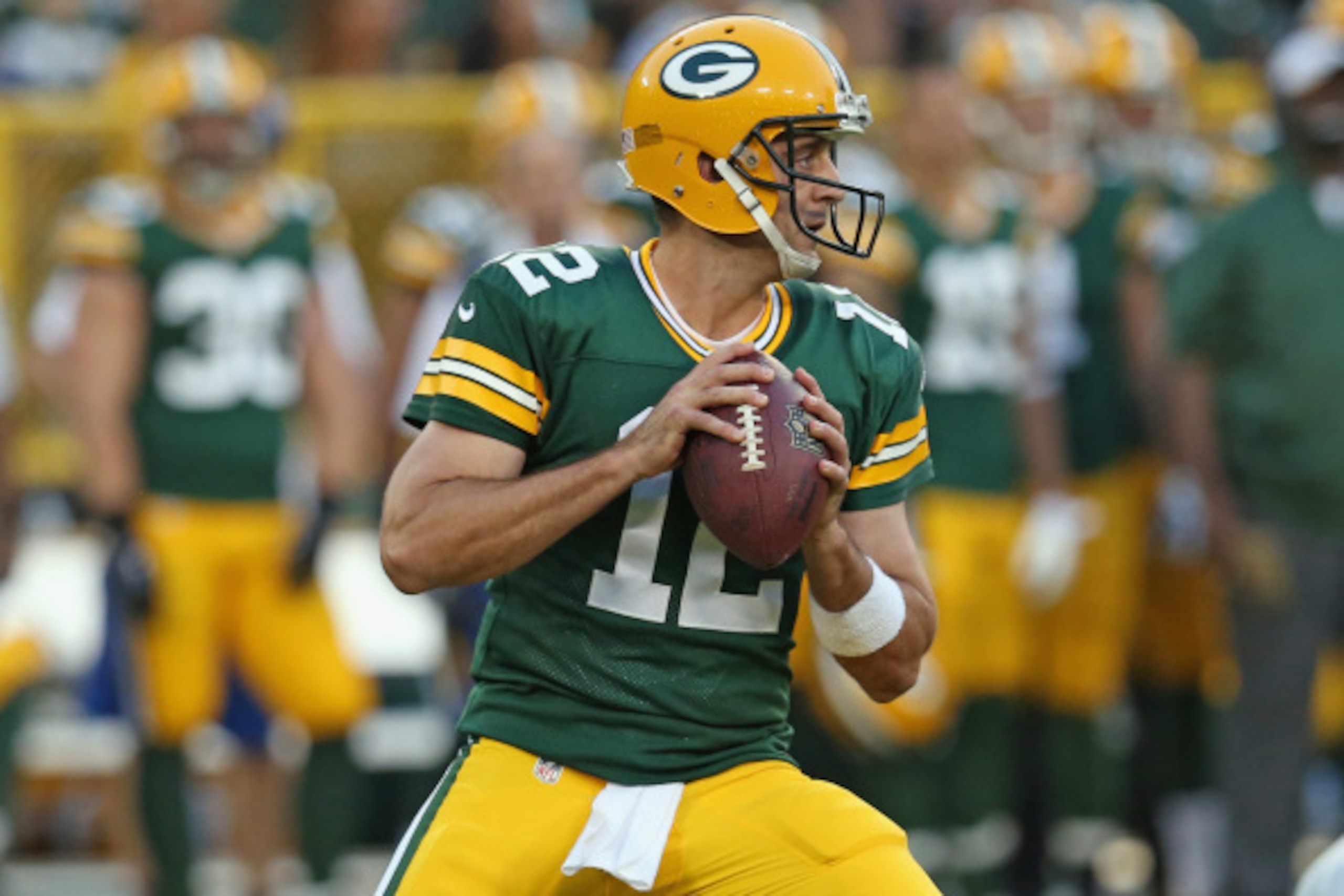 GREEN BAY, WI - AUGUST 22:  Quarterback Aaron Rodgers #12 of the Green Bay Packers looks to pass during the first quarter of a preseason game against the Oakland Raiders at Lambeau Field on August 22, 2014 in Green Bay, Wisconsin.  (Photo by Jonathan Dani