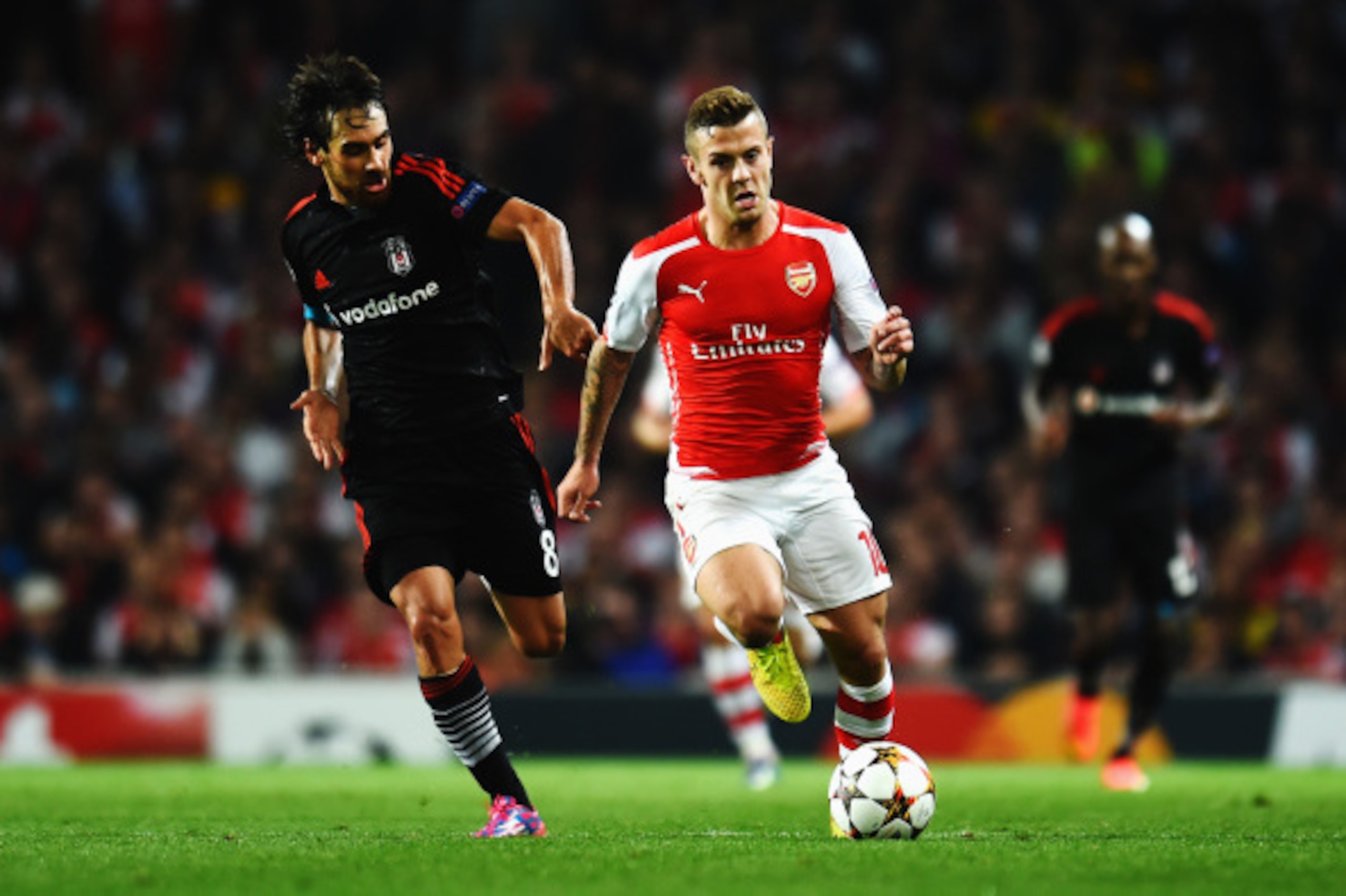 LONDON, ENGLAND - AUGUST 27:  Jack Wilshere (R) of Arsenal holds off the challenge of Veli Kavlak of Besiktas during the UEFA Champions League Qualifier 2nd leg match between Arsenal and Besiktas at the Emirates Stadium on August 27, 2014 in London, Unite