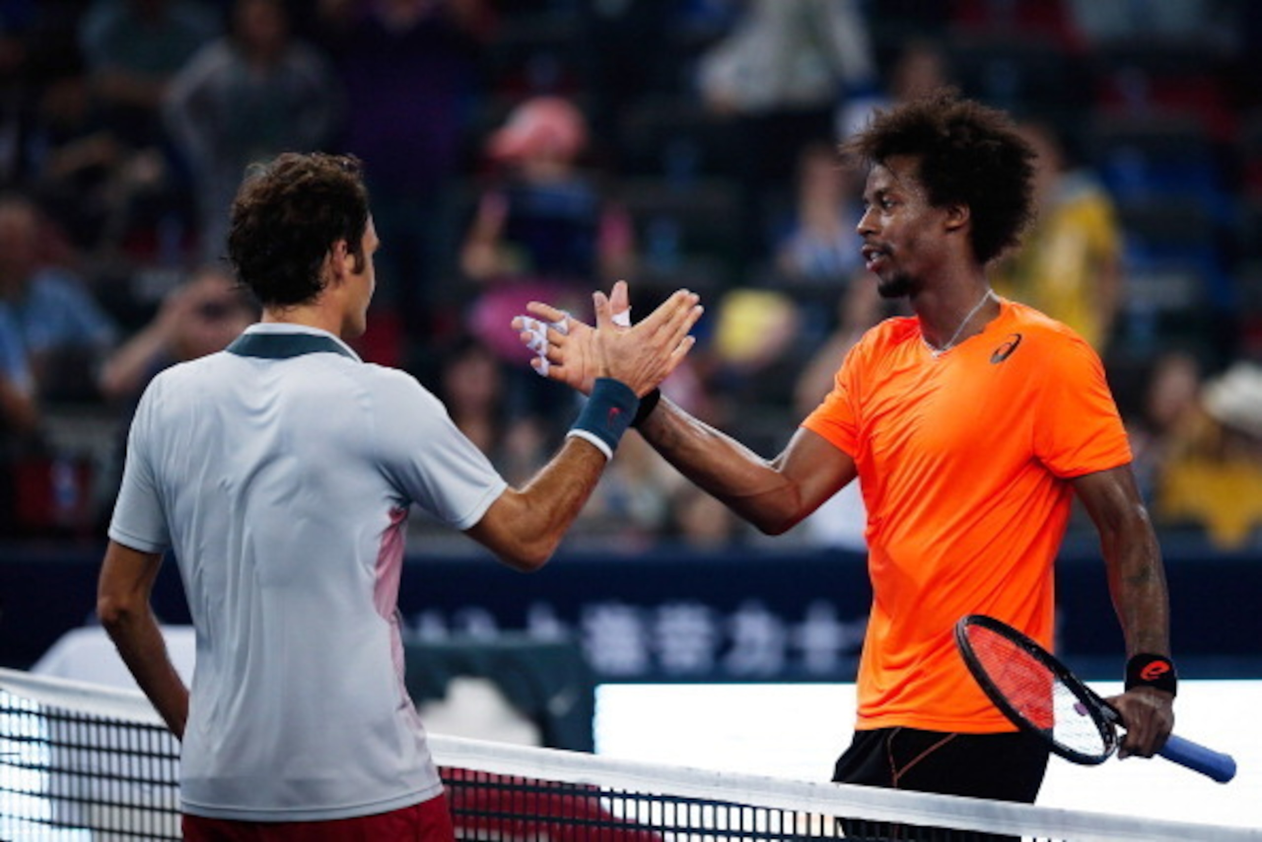 SHANGHAI, CHINA - OCTOBER 10: Gael Monfils (R) of France shake hands with Roger Federer of Switzerland after his win game during day four of the Shanghai Rolex Masters at the Qi Zhong Tennis Center on October 9, 2013 in Shanghai, China.  (Photo by Lintao 