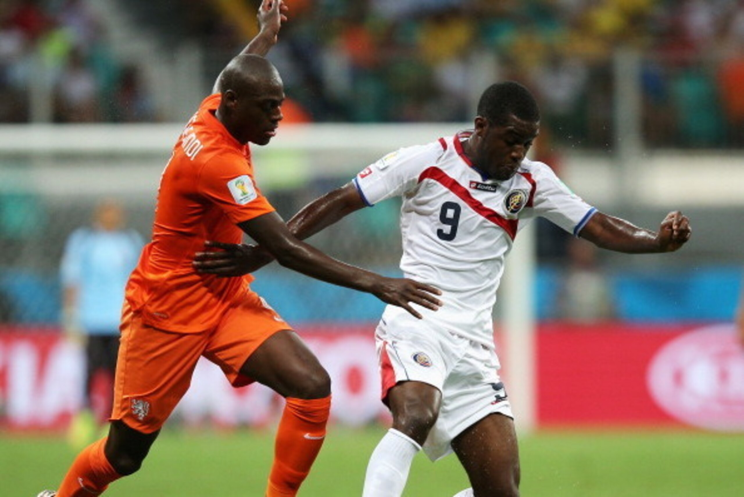 SALVADOR, BRAZIL - JULY 05:  Bruno Martins Indi of the Netherlands challenges Joel Campbell of Costa Rica during the 2014 FIFA World Cup Brazil Quarter Final match between the Netherlands and Costa Rica at Arena Fonte Nova on July 5, 2014 in Salvador, Bra