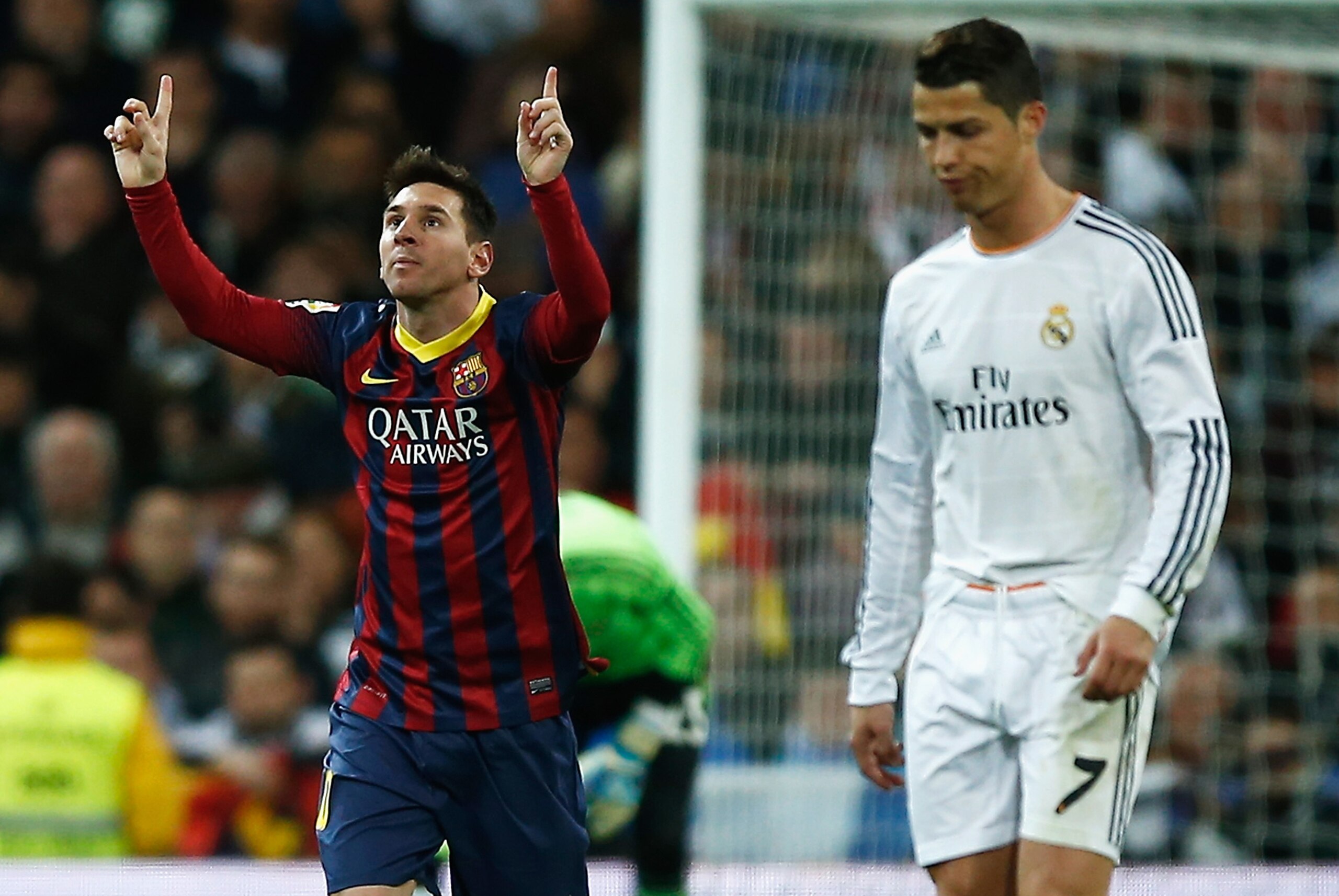 MADRID, SPAIN - MARCH 23:  Lionel Messi of Barcelona celebrates scoring his team's third goal as Cristiano Ronaldo of Real Madrid looks dejected during the La Liga match between Real Madrid CF and FC Barcelona at the Bernabeu on March 23, 2014 in Madrid,
