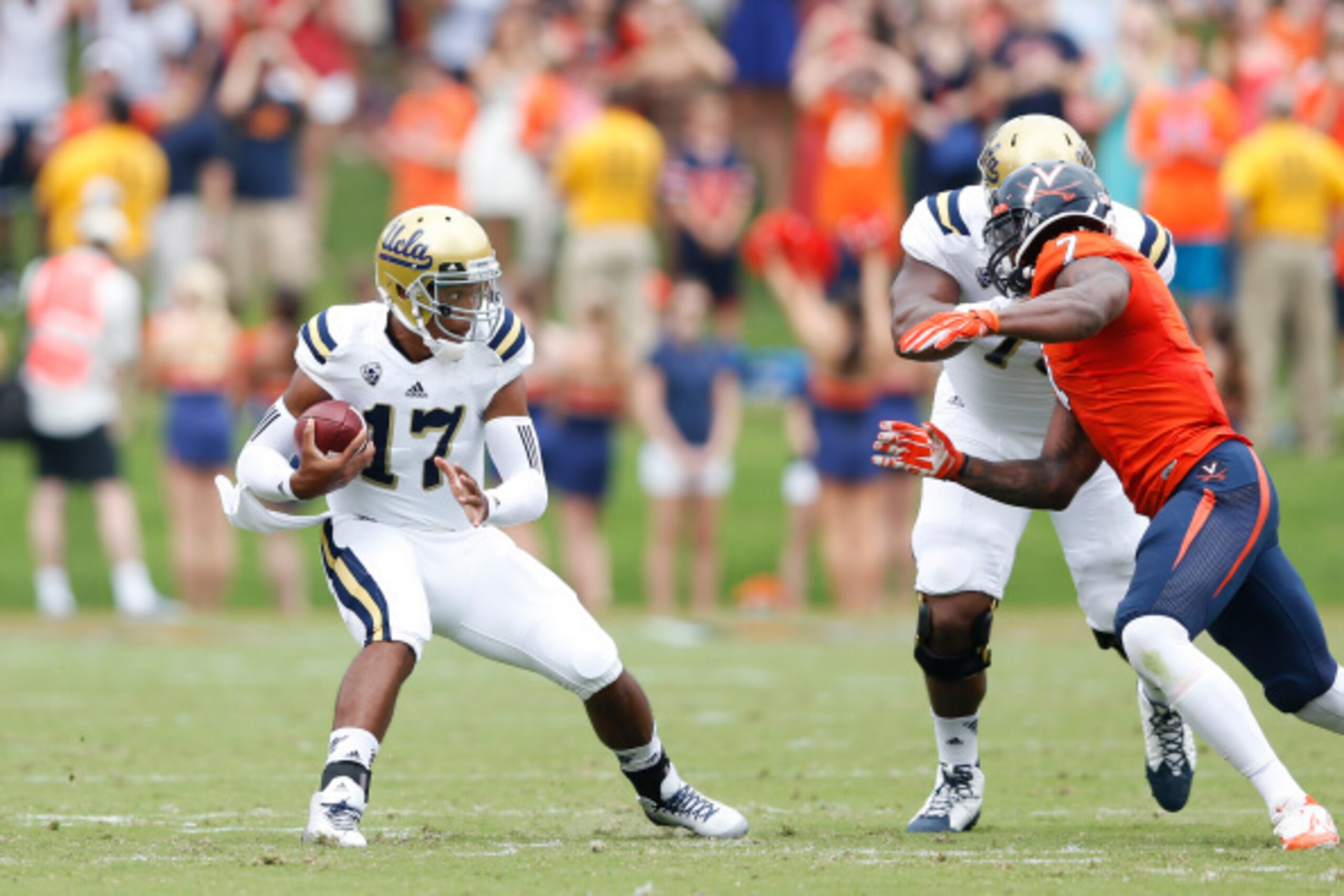 CHARLOTTESVILLE, VA - AUGUST 30: Brett Hundley #17 of the UCLA Bruins looks to evade pressure from Eli Harold #7 of the Virginia Cavaliers during first half action at Scott Stadium on August 30, 2014 in Charlottesville, Virginia. (Photo by Joe Robbins/Get
