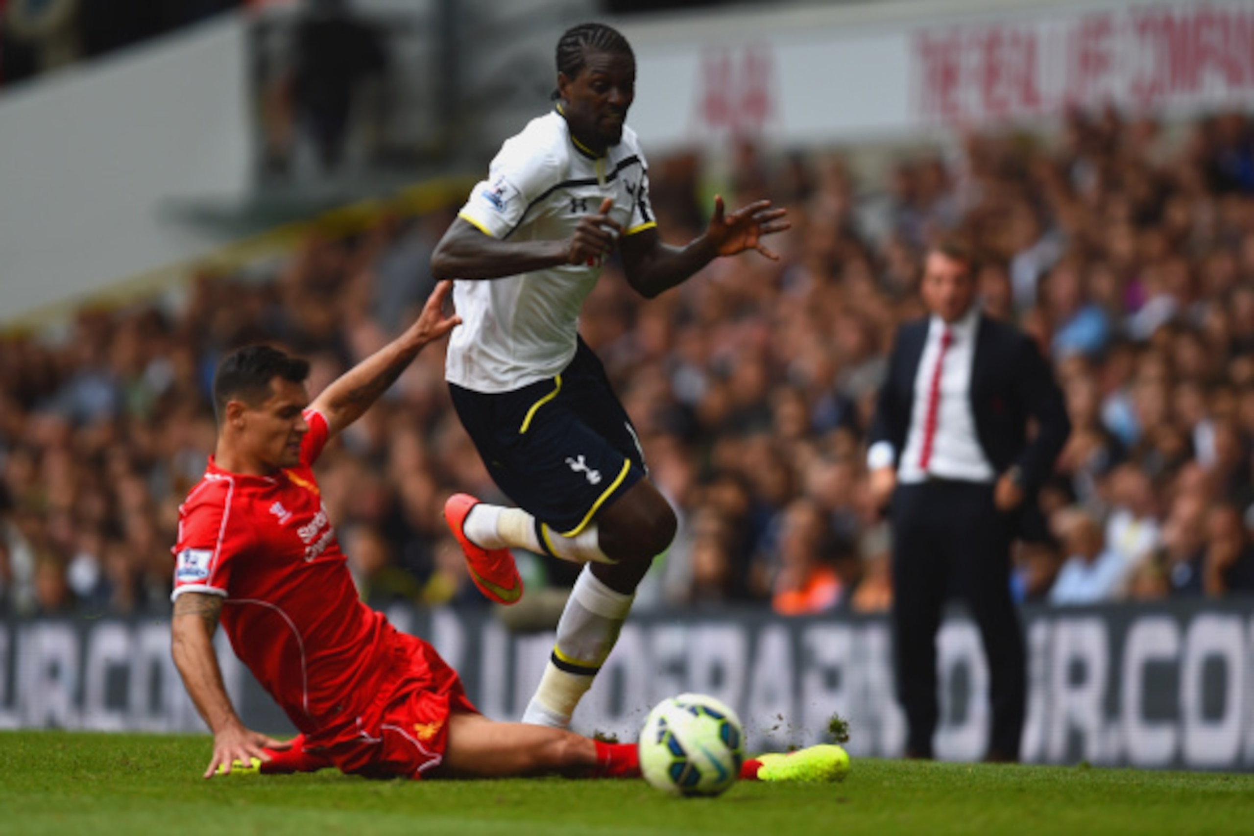 LONDON, ENGLAND - AUGUST 31:  Emmanuel Adebayour of Spurs is tackled by Dejan Lovren of Liverpool during the Barclays Premier League match between Tottenham Hotspur and Liverpool at White Hart Lane on August 31, 2014 in London, England.  (Photo by Jamie M
