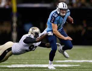 NEW ORLEANS, LA - AUGUST 15:  Junior Galette #93 of the New Orleans Saints tackles Jake Locker #10 of the Tennessee Titans during a preseason game between the New Orleans Saints and the Tennessee Titans at Mercedes-Benz Superdome on August 15, 2014 in New