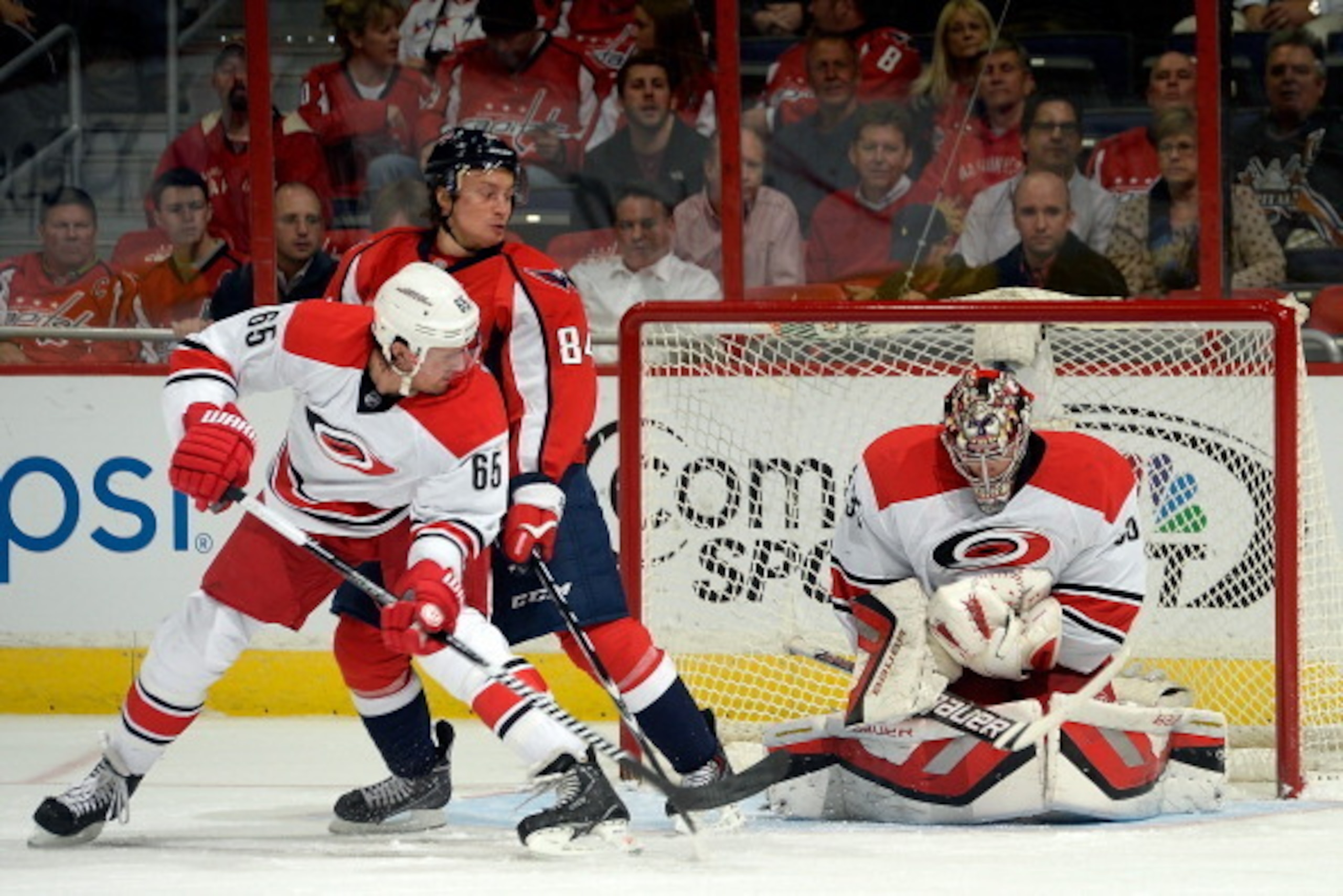 WASHINGTON, DC - DECEMBER 03:  Justin Peters #35 of the Carolina Hurricanes makes a save in the first period as Mikhail Grabovski #84 of the Washington Capitals and Ron Hainsey #65 of the Carolina Hurricanes battle in front of the net during an NHL game a