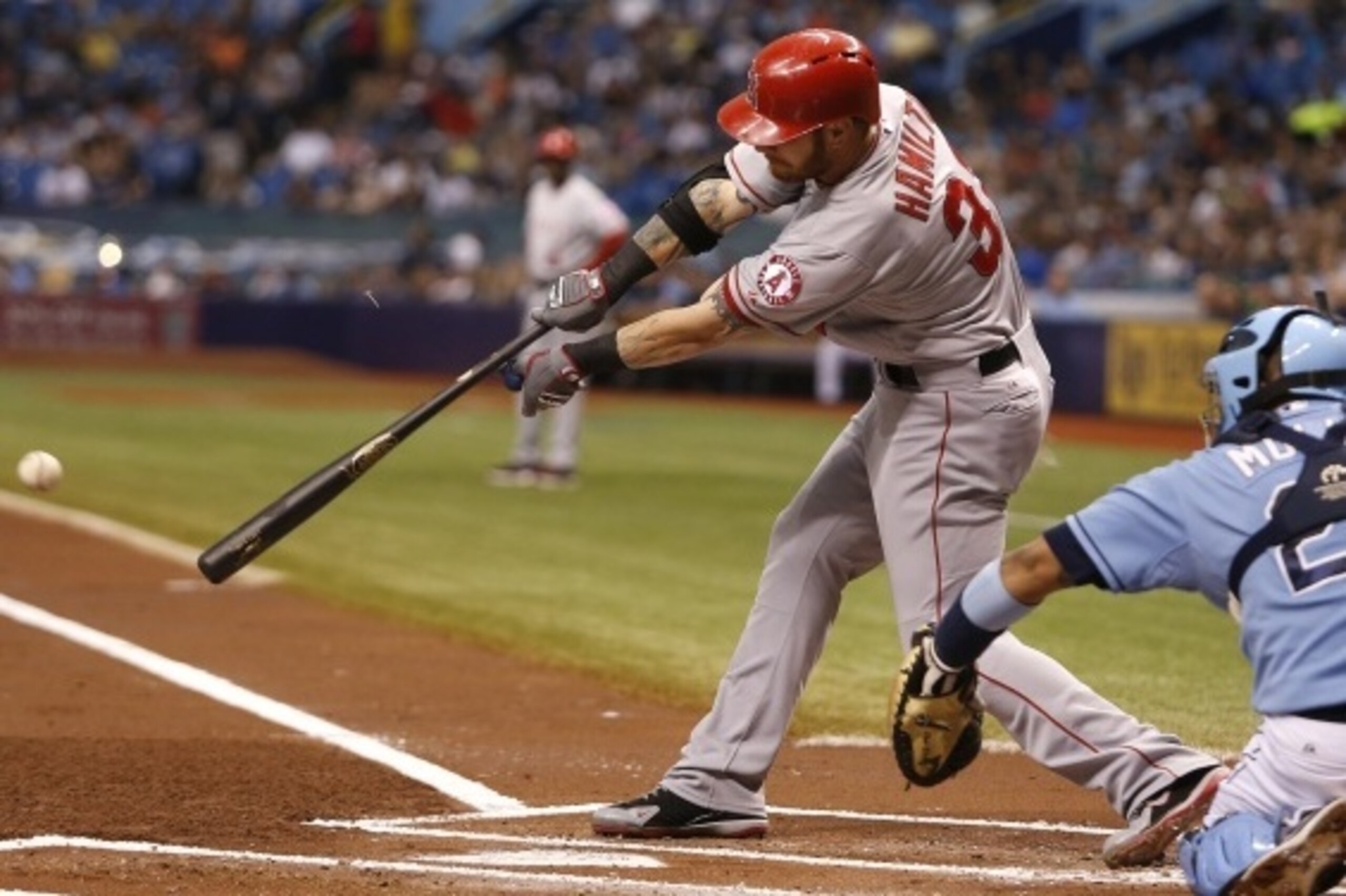 ST. PETERSBURG, FL - AUGUST 3:  Josh Hamilton #32 of the Los Angeles Angels of Anaheim hits a one-run single in front of catcher Jose Molina #28 of the Tampa Bay Rays to score Mike Trout during the first inning of a game on August 3, 2014 at Tropicana Fie