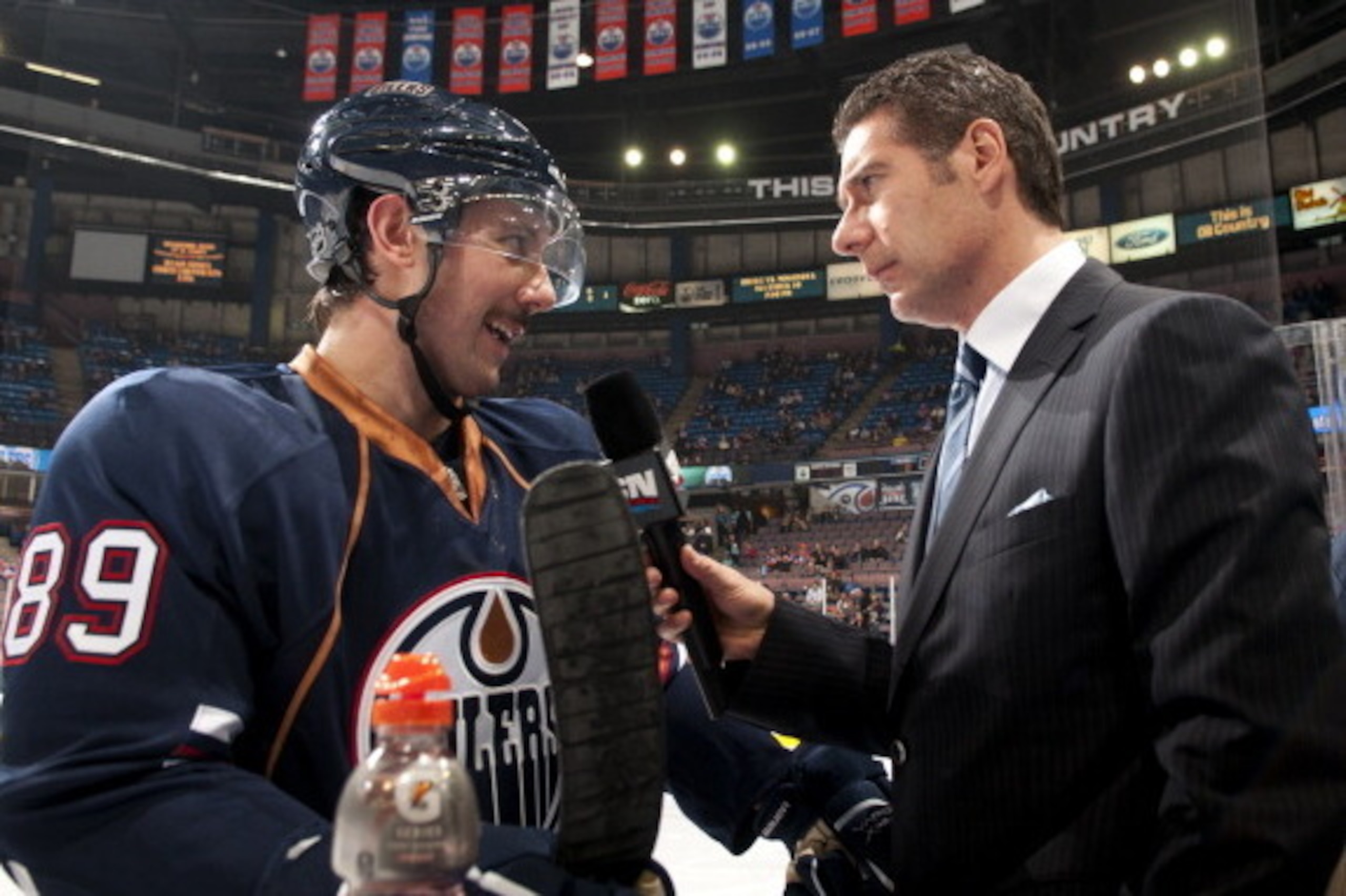 EDMONTON, CANADA - NOVEMBER 28:  Sam Ganger #89 of the Edmonton Oilers is interviewed by Gene Principe of Sportsnet before a game against the Nashville Predators at Rexall Place on November 28, 2011 in Edmonton, Alberta, Canada. (Photo by Andy Devlin/NHLI