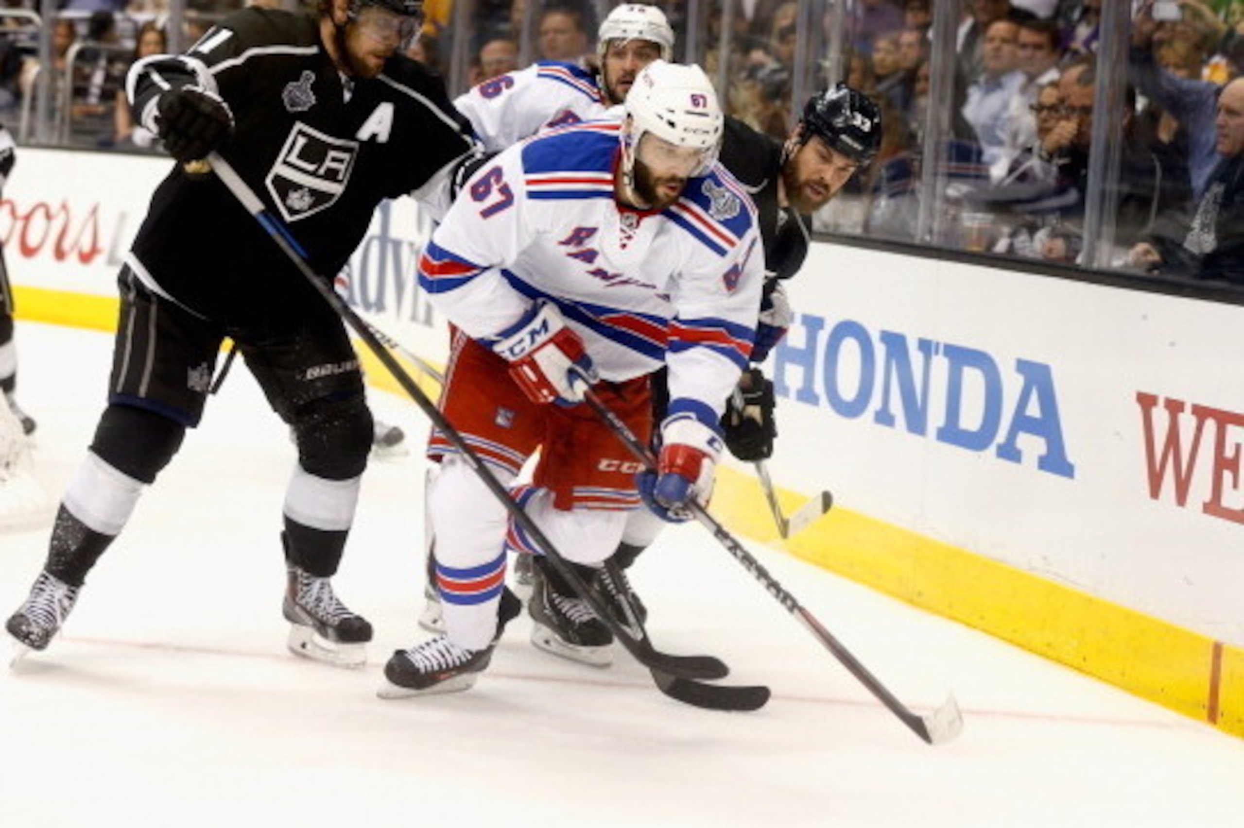 LOS ANGELES, CA - JUNE 13:  Benoit Pouliot #67 of the New York Rangers skates away from Anze Kopitar #11 and Willie Mitchell #33 of the Los Angeles Kings during the third period of Game Five of the 2014 Stanley Cup Final at the Staples Center on June 13, 