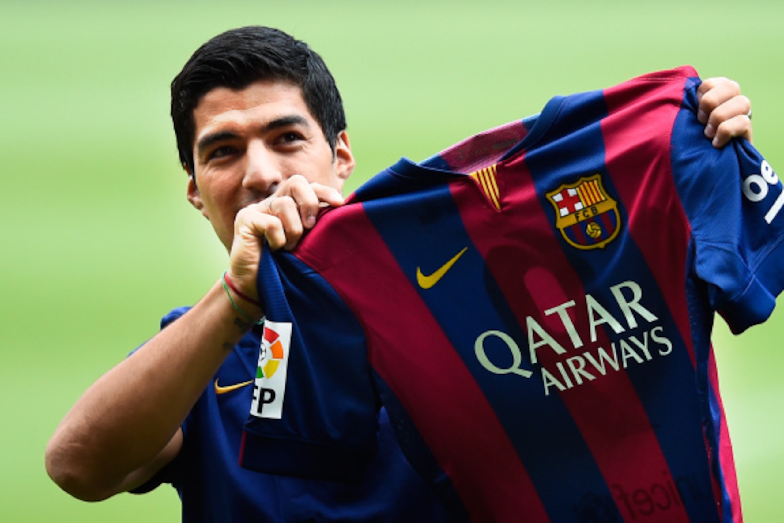 BARCELONA, SPAIN - AUGUST 19:  Luis Suarez of FC Barcelona holds a FC Barcelona shirt during his presentation as new FC Barcelona player at Camp Nou on August 19, 2014 in Barcelona, Spain.  (Photo by David Ramos/Getty Images)