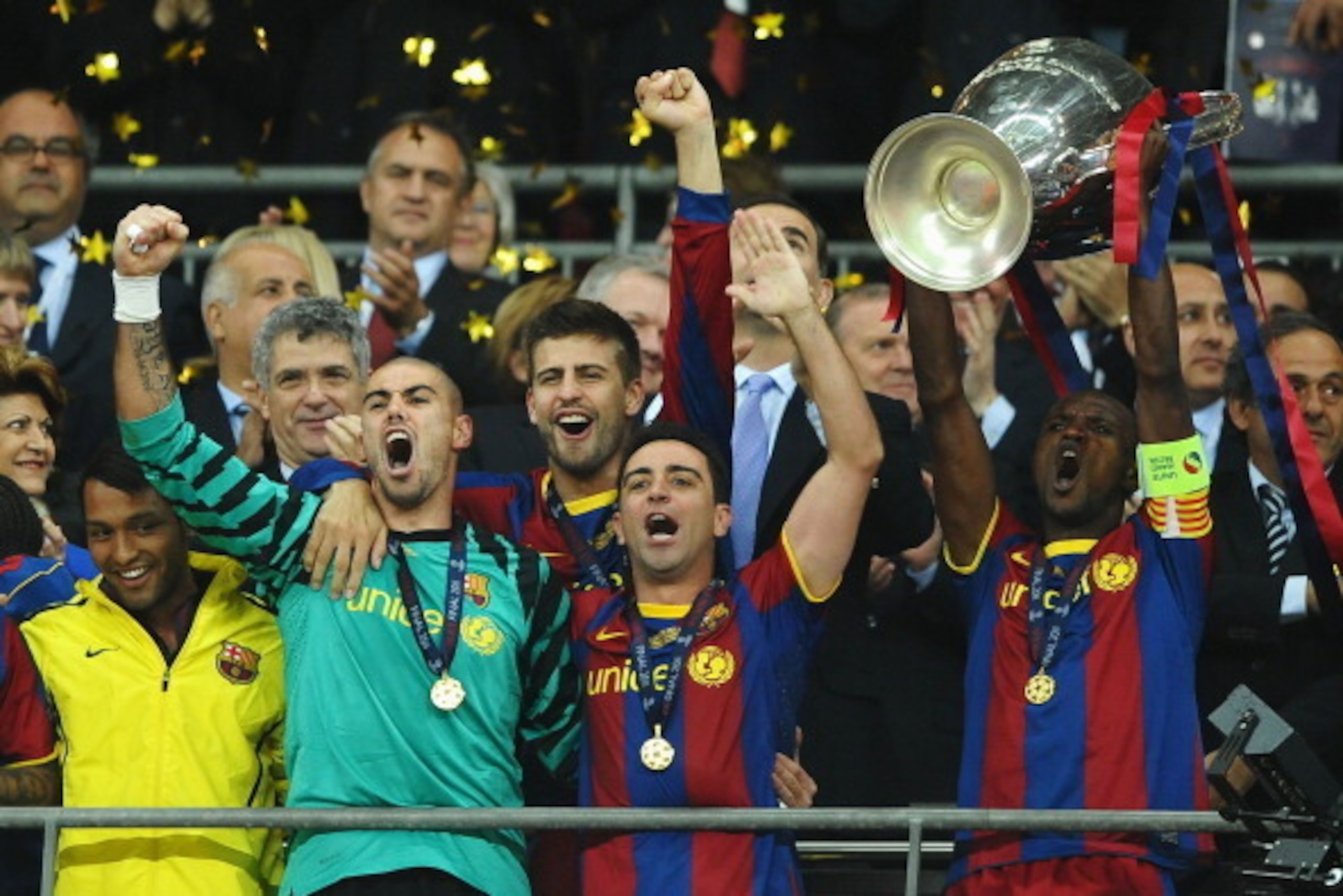LONDON, ENGLAND - MAY 28:  Eric Abidal (R) of FC Barcelona lifts the trophy and celebrates with teammates Victor Valdes (2L), Xavi (2R) and Gerard Pique (behind) after victory in the UEFA Champions League final between FC Barcelona and Manchester United F
