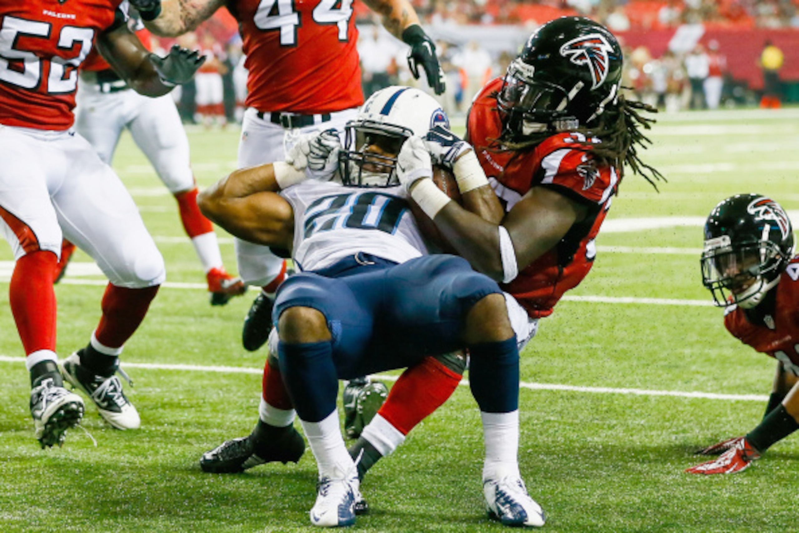 ATLANTA, GA - AUGUST 23:  Bishop Sankey #20 of the Tennessee Titans is tackled by Kemal Ishmael #36 of the Atlanta Falcons close to the endzone in the second half of a preseason game at the Georgia Dome on August 23, 2014 in Atlanta, Georgia.  (Photo by K