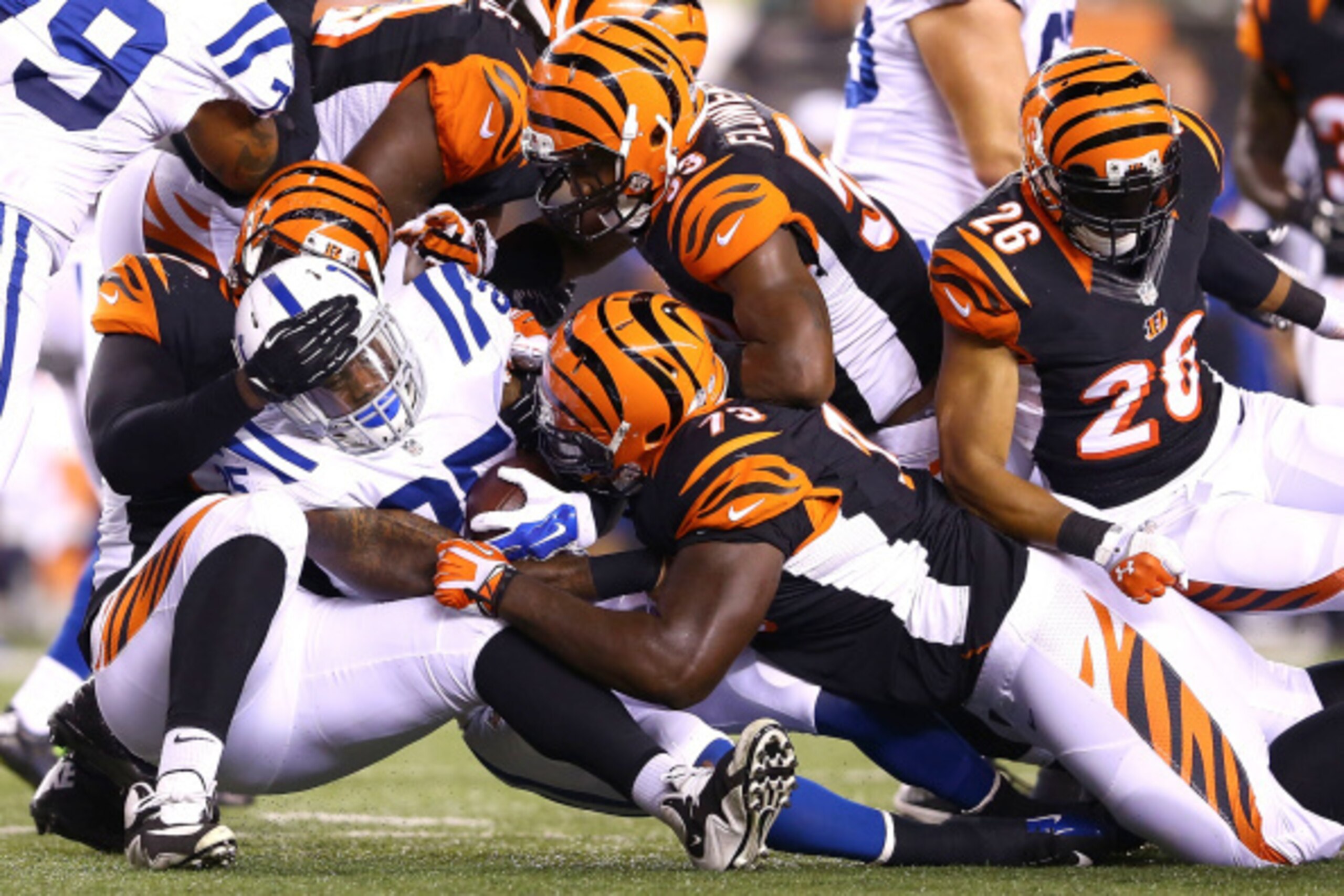 CINCINNATI, OH - AUGUST 28:  Christo Bilukidi #90, Trey Hopkins #73, and Marquis Flowers #53, all of the Cincinnati Bengals, combine to tackle David Fuellen #25 of the Indianapolis Colts during the third quarter at Paul Brown Stadium on August 28, 2014 in