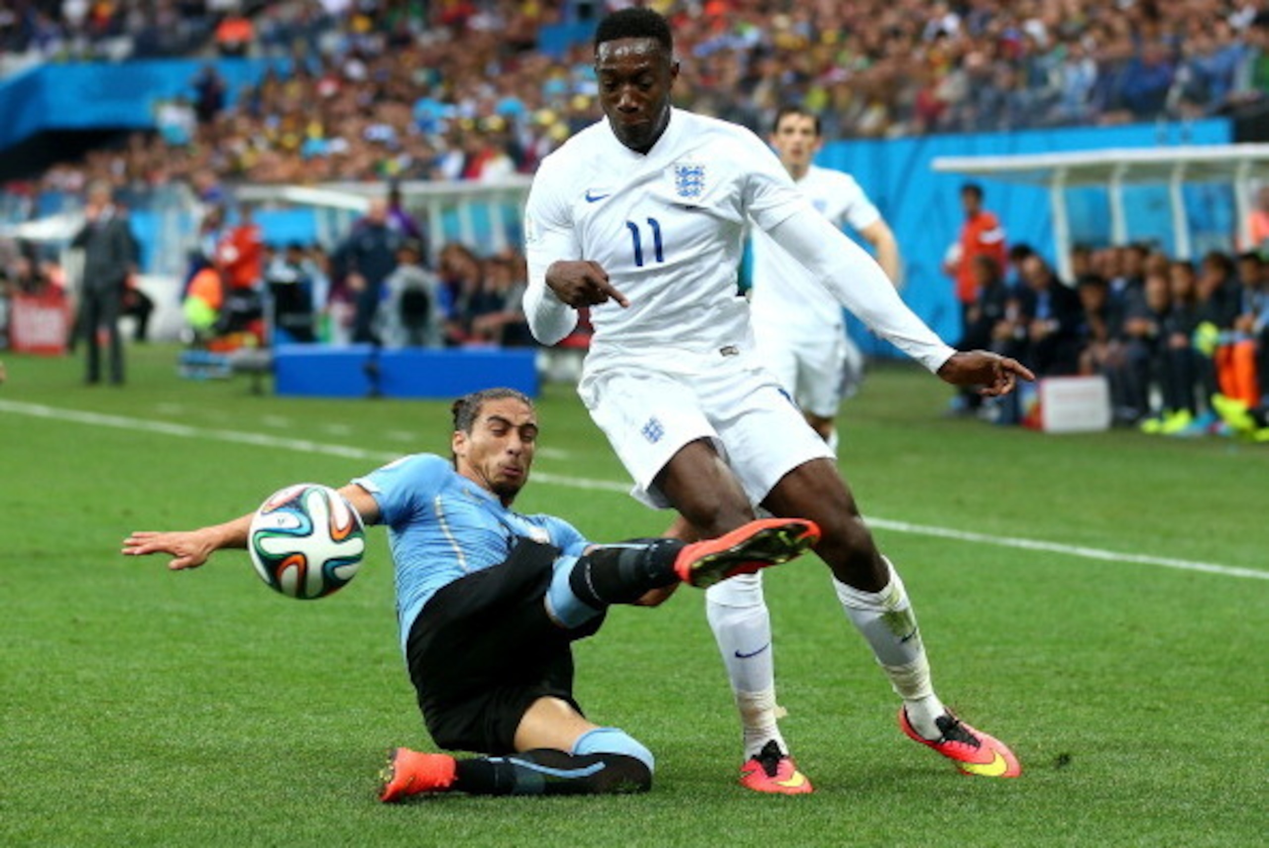 SAO PAULO, BRAZIL - JUNE 19:  Martin Caceres of Uruguay tackles Danny Welbeck of England during the 2014 FIFA World Cup Brazil Group D match between Uruguay and England at Arena de Sao Paulo on June 19, 2014 in Sao Paulo, Brazil.  (Photo by Julian Finney/