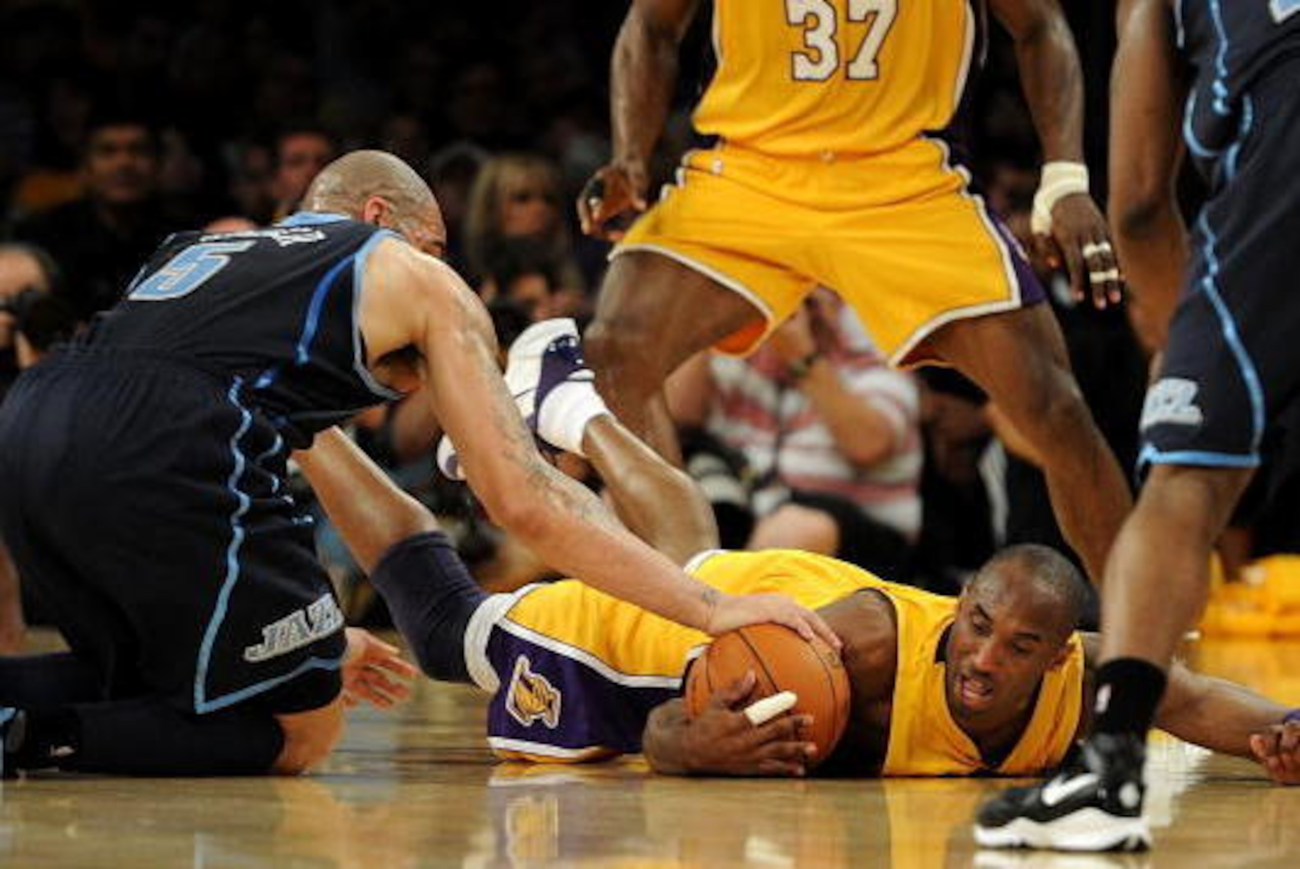 LOS ANGELES, CA - MAY 04:  Kobe Bryant #24 of the Los Angeles Lakers dives for a loose ball against Carlos Boozer #5 of the Utah Jazz in the first half during Game Two of the Western Conference Semifinals of the 2010 NBA Playoffs at Staples Center on May 